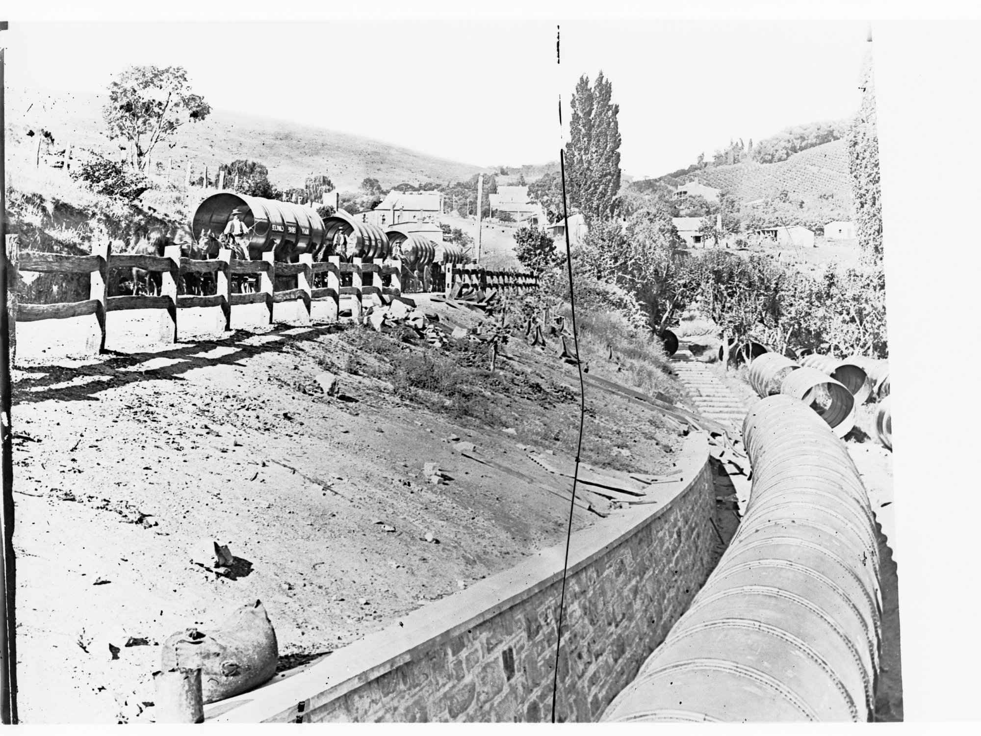 Constructions workers delivering pipe for the Happy Valley Waterworks pipeline - Clarendon township in background