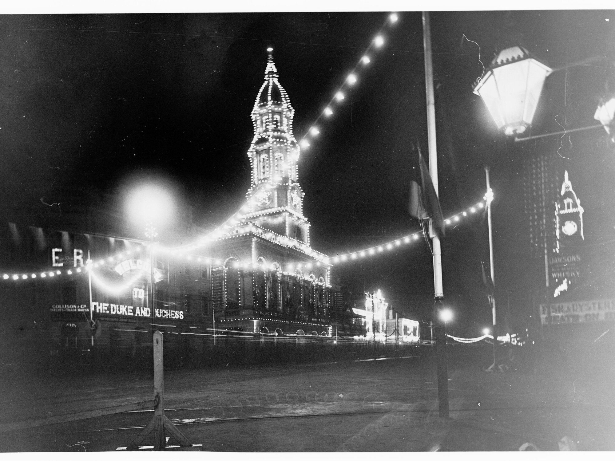 King William Street illuminated at night - for Duke of York's visit - a lit sign says Welcome to the Duke and Duchess