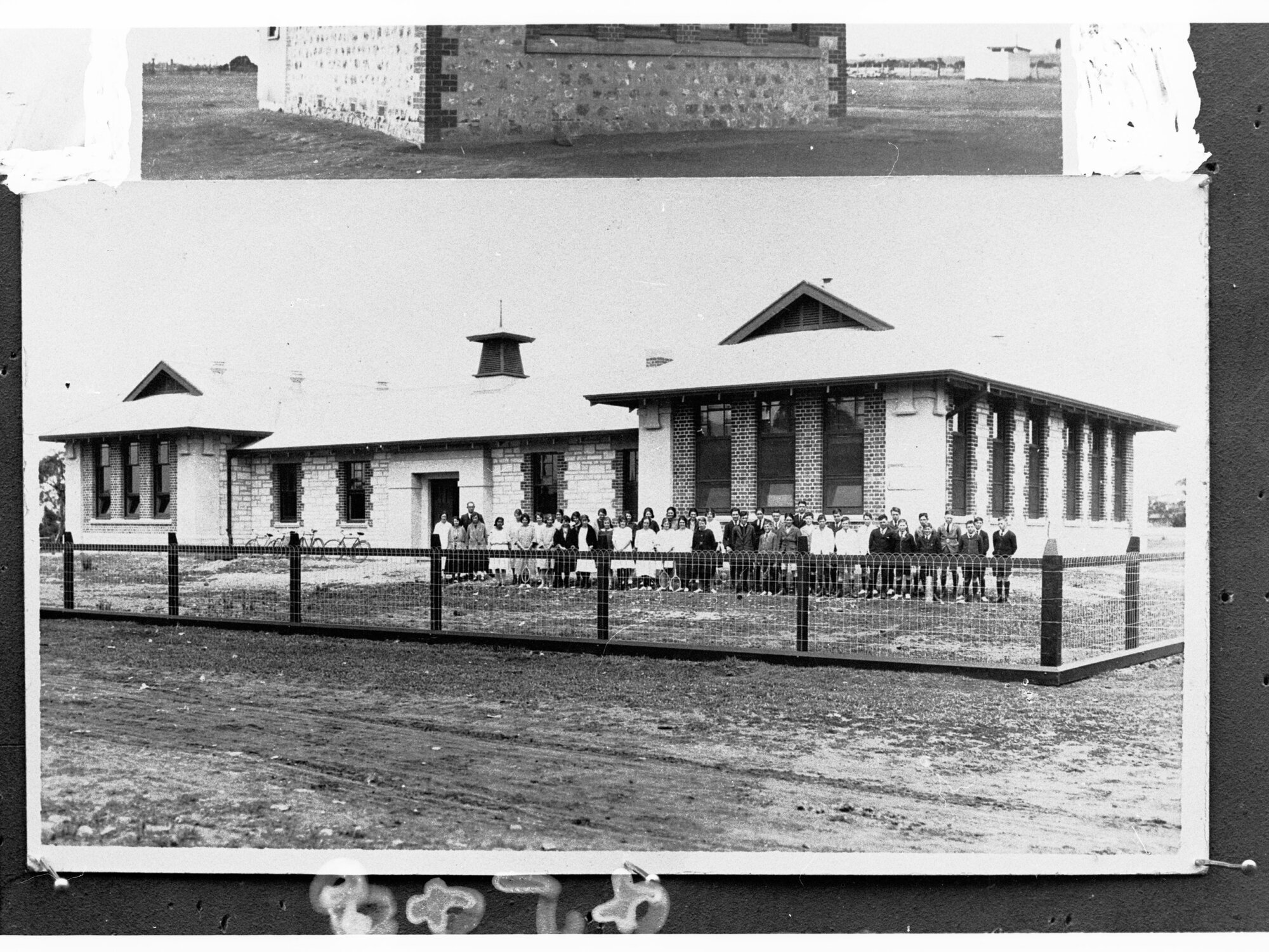 Children standing in a group outside a country school - area unknown
