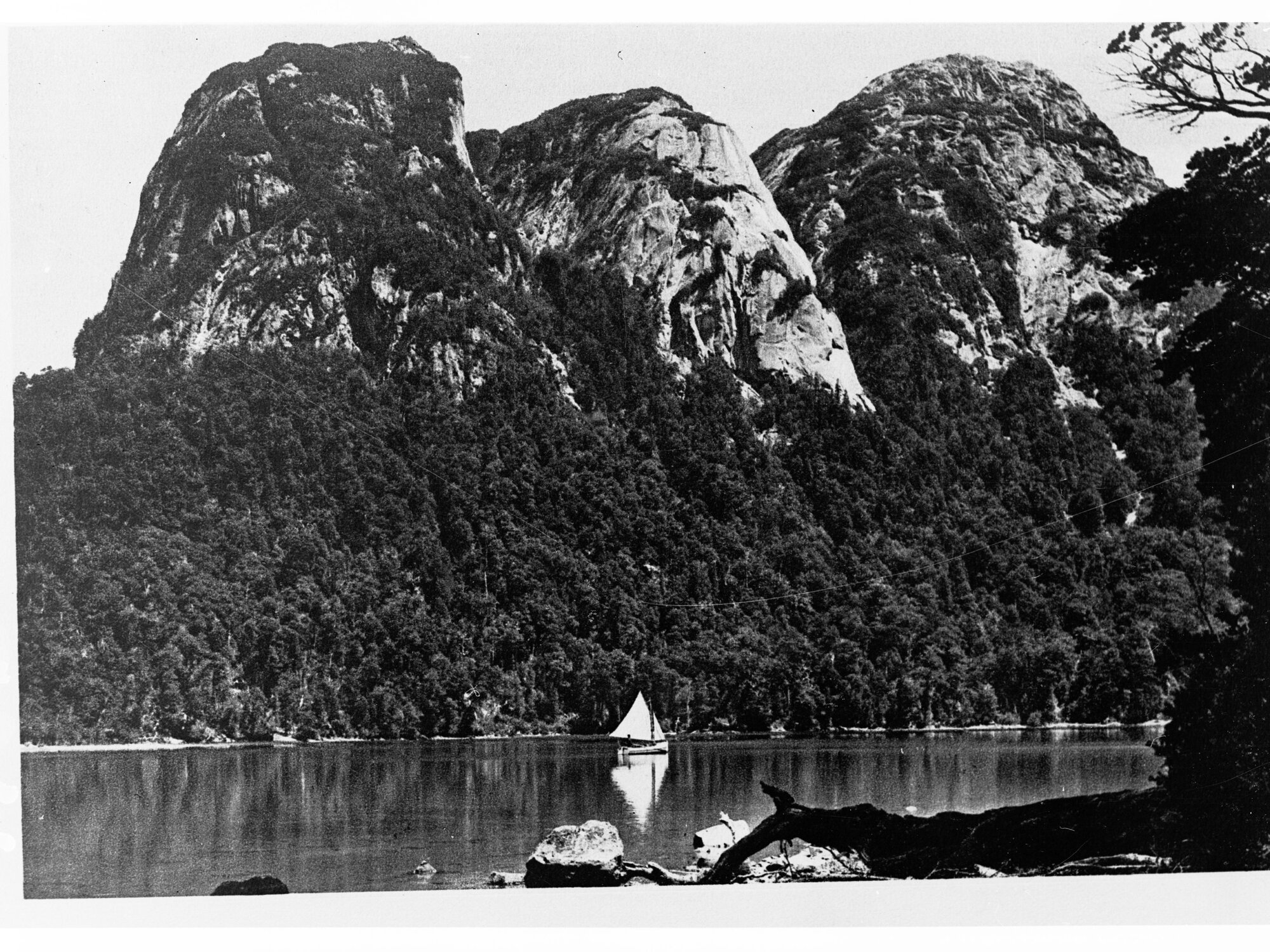 Sailboat on a Lake With Steep Mounatins Behind