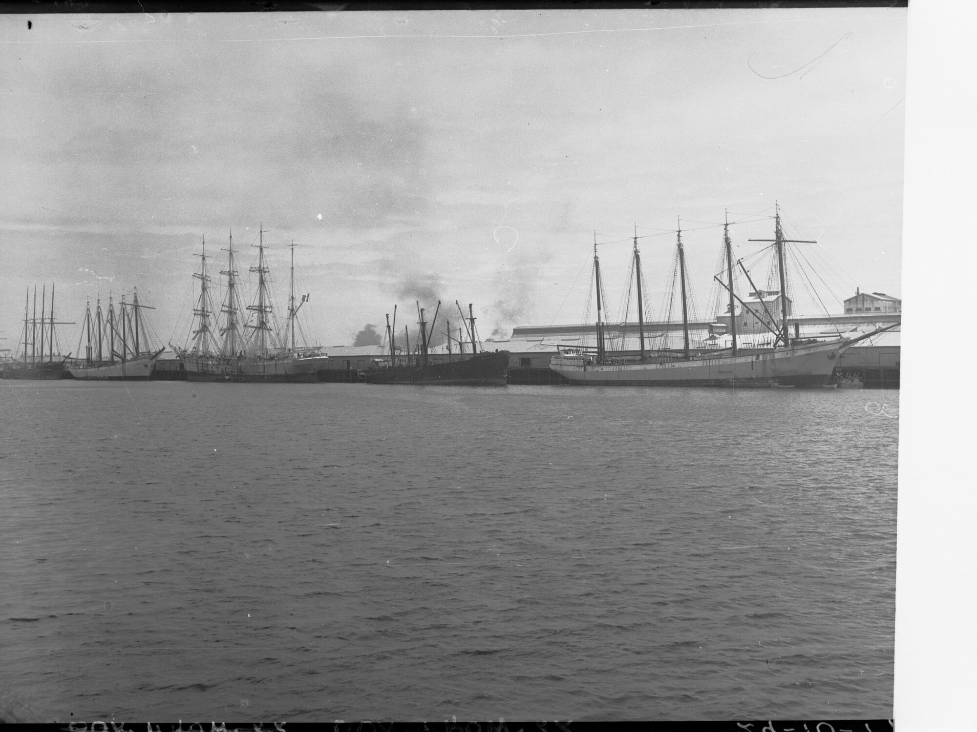 Sailing ships berthed at wharf - location unknown