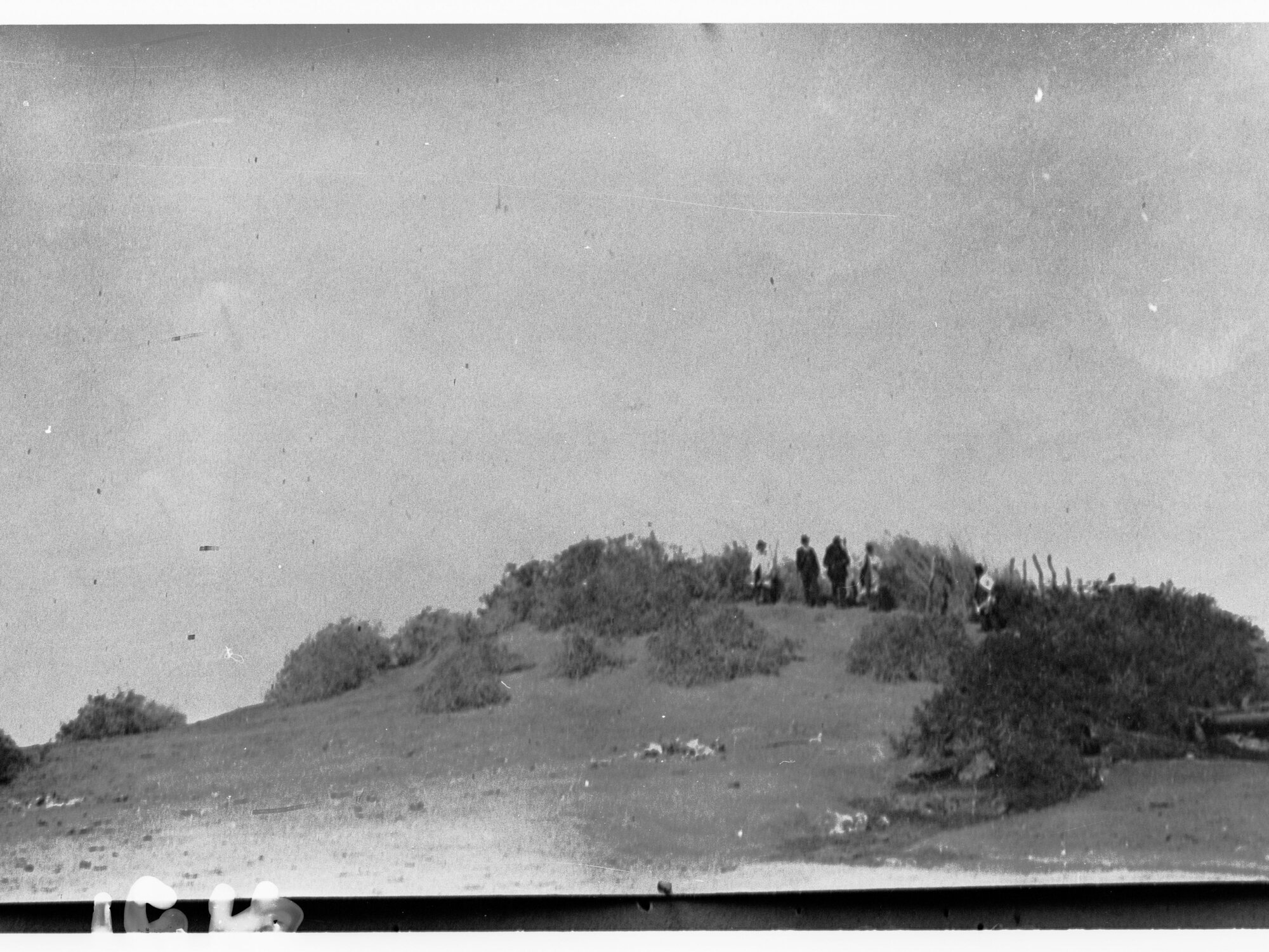 Men standing in the desert on sandy ridge - area unknown