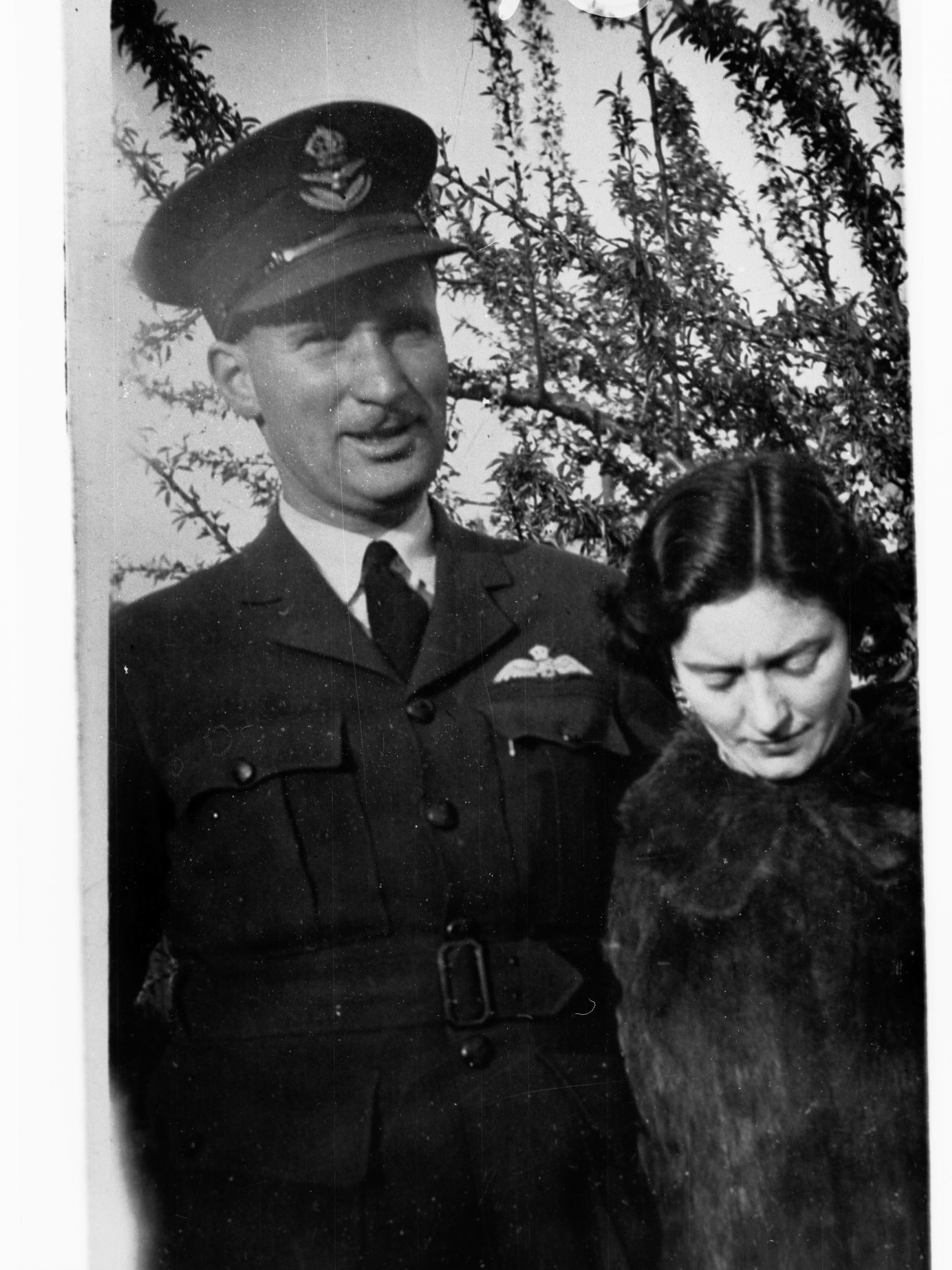 Portrait of an officer in Royal Australian Air Force - photo copied for Roll of Honour (lady is also in photograph)