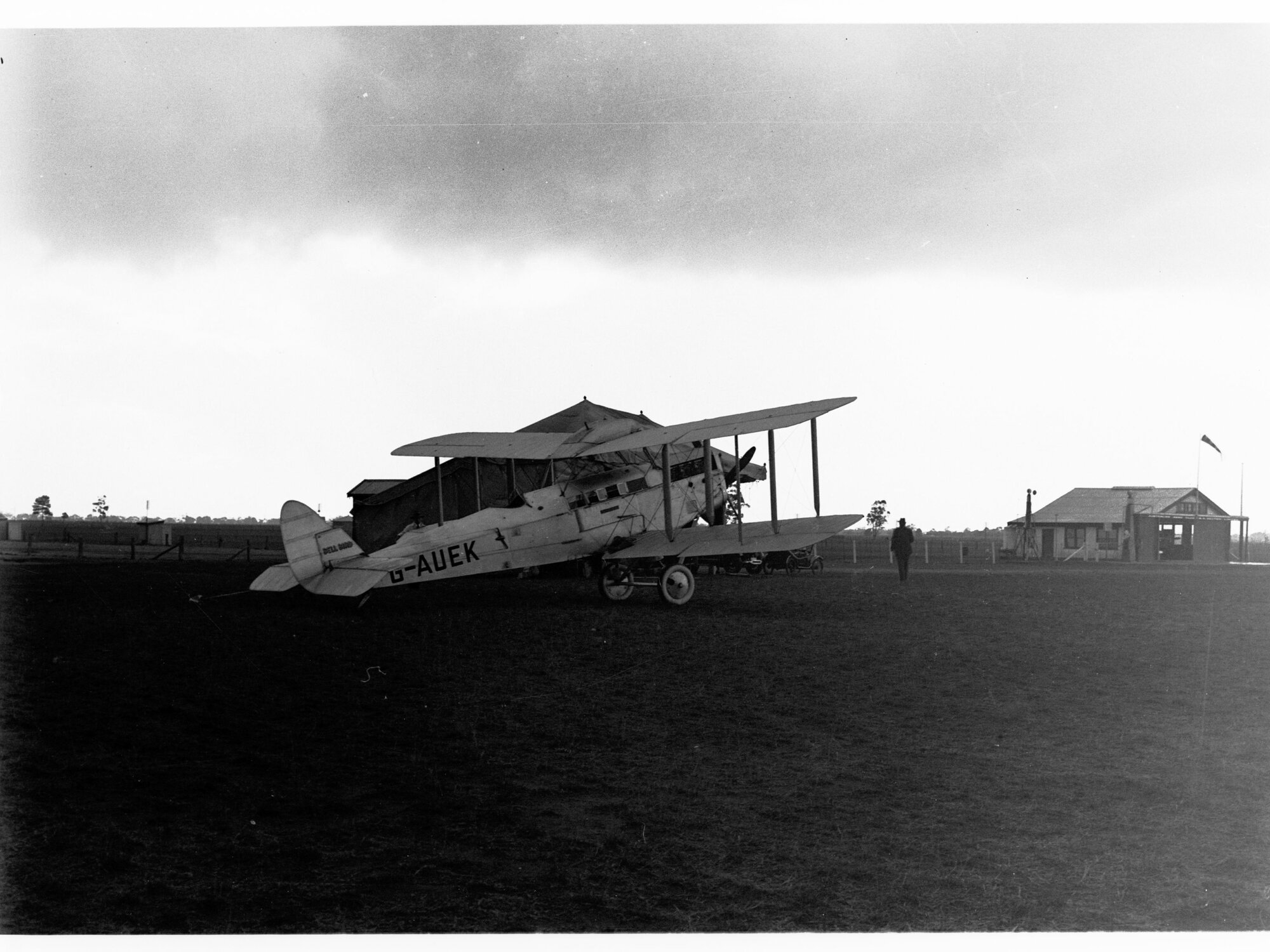 A de Havilland aeroplane, a DH50A, named Bellbird (probably located at an aerodrome in Parafield) - two men getting into plane