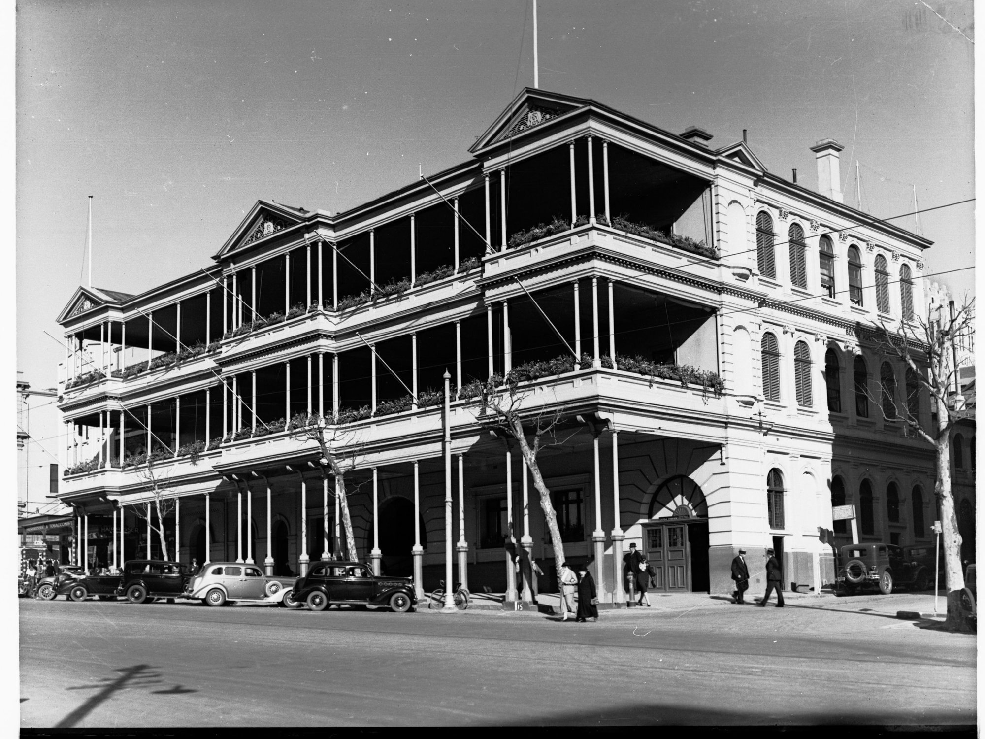 South Australian hotel, North Terrace, decorated for state centenary, opposite Adelaide railway station, automobiles parked outside