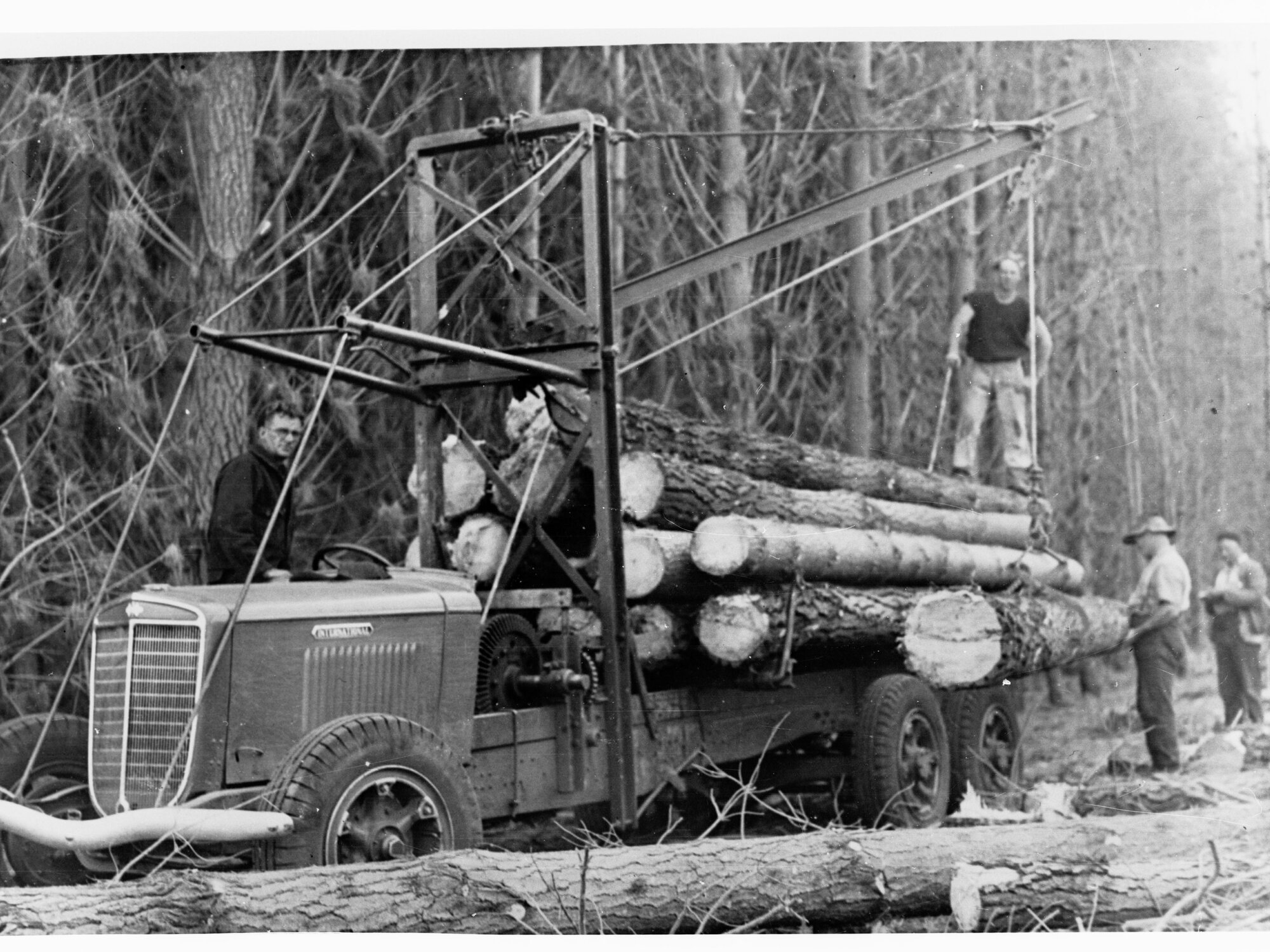 Men loading logs onto a truck