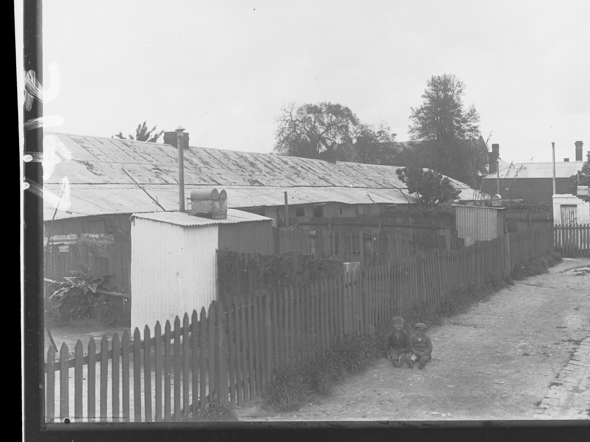 Backyards of row of houses (two children sitting on ground) , Shannon Place, Adelaide South Australia