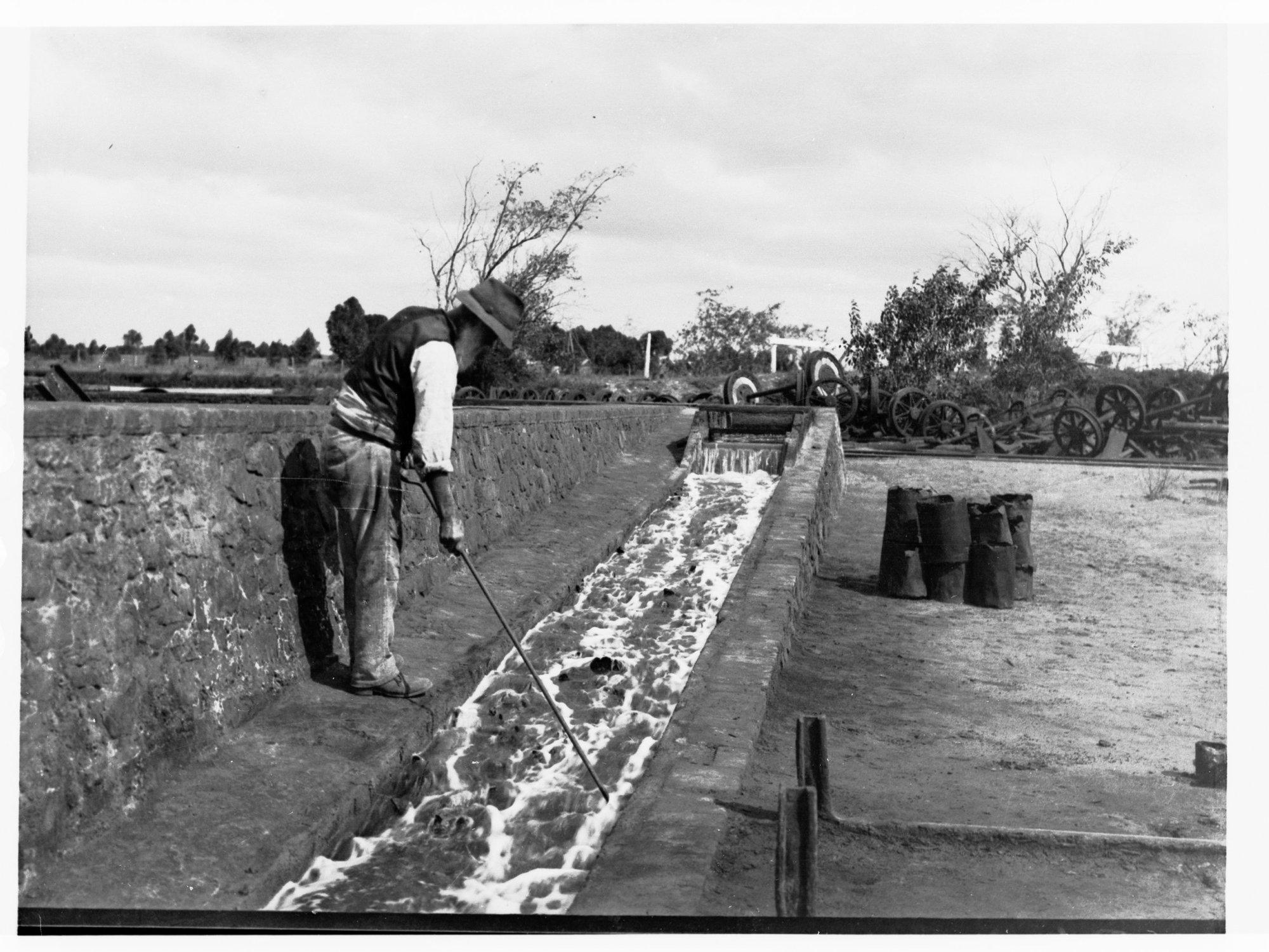 Cementation works at Moonta Mines, raking copper precipitate from scrap iron in canals, men working