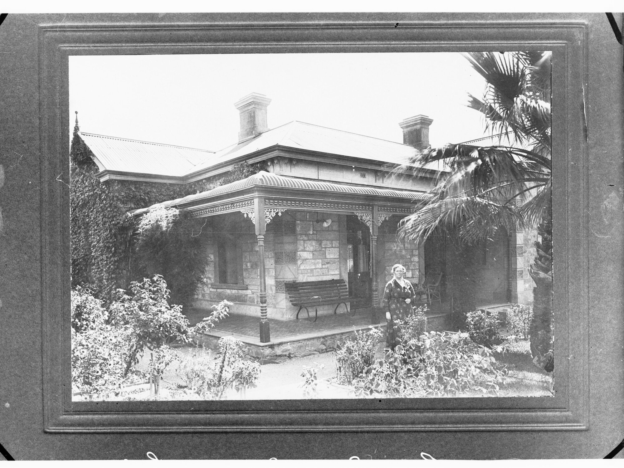 Front view of house showing lady in garden (Public Service Commissioner)