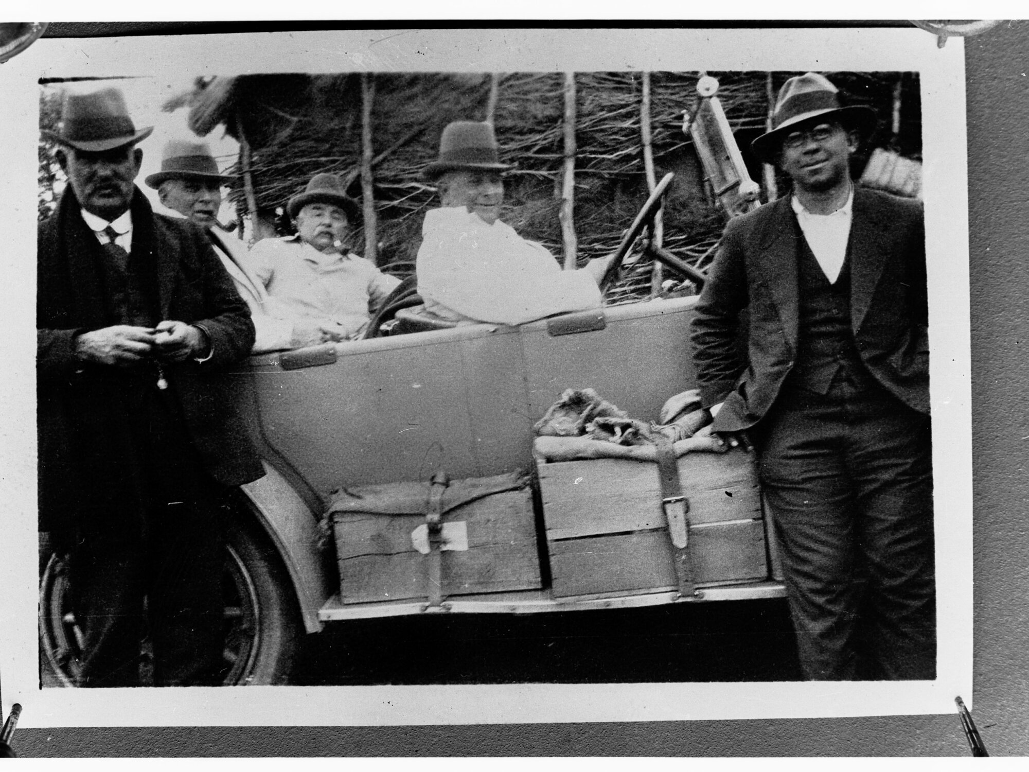 Photograph of men near automobile