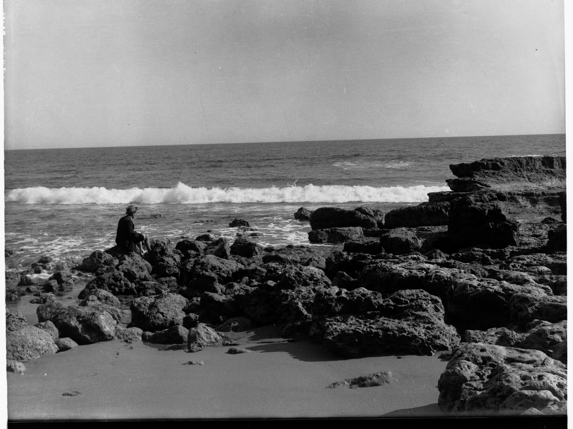 Man Sitting on Rocks at Port Noarlunga