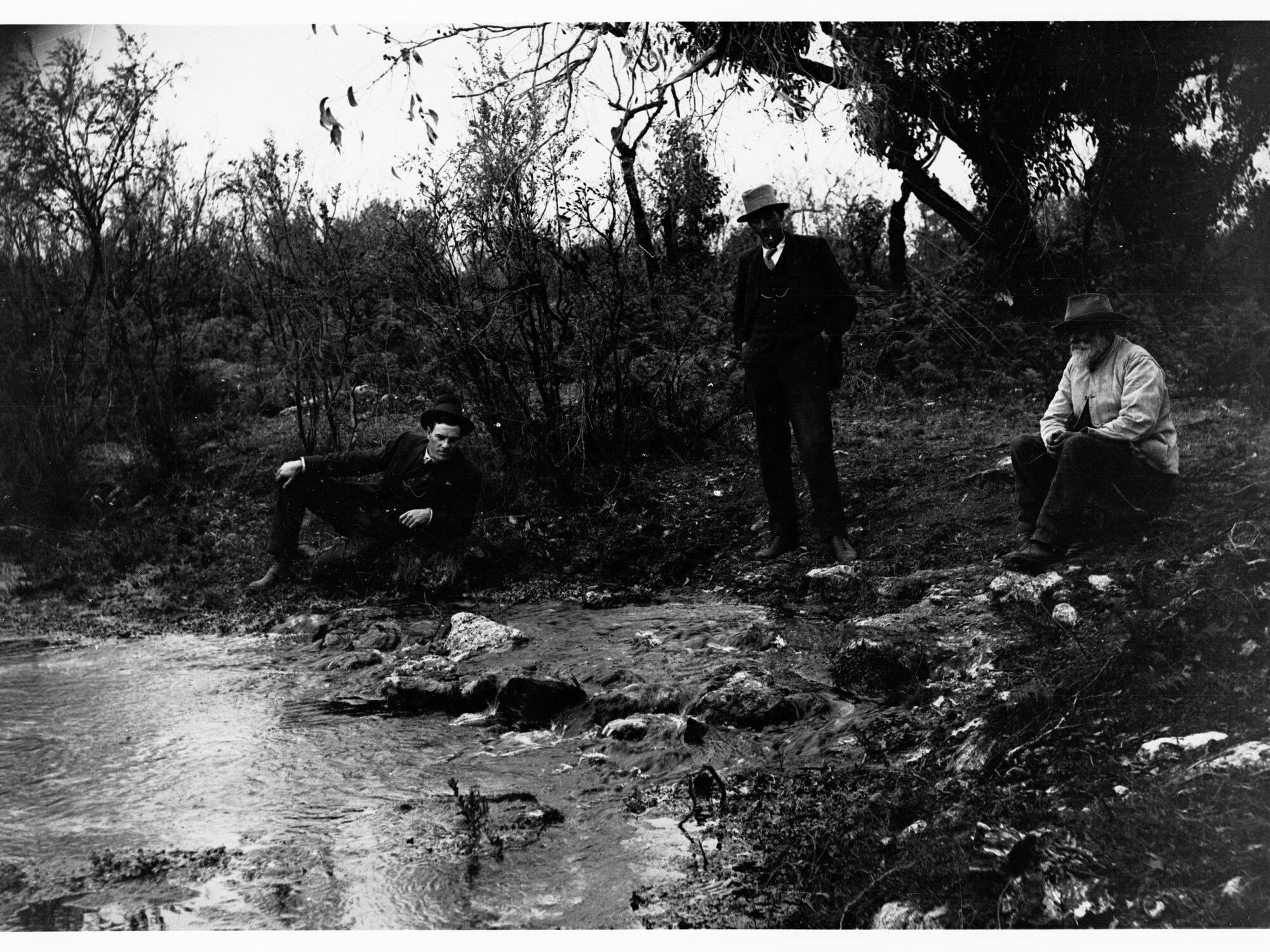 Men sitting on rocks next to a spring - near Mount Gambier