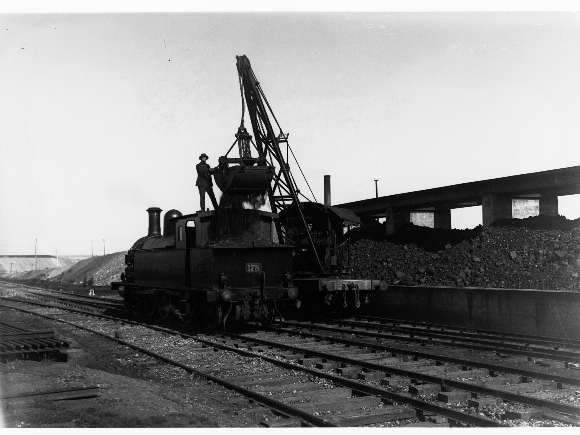Loading coal from bunkers into 1st class locomotive at Mile End