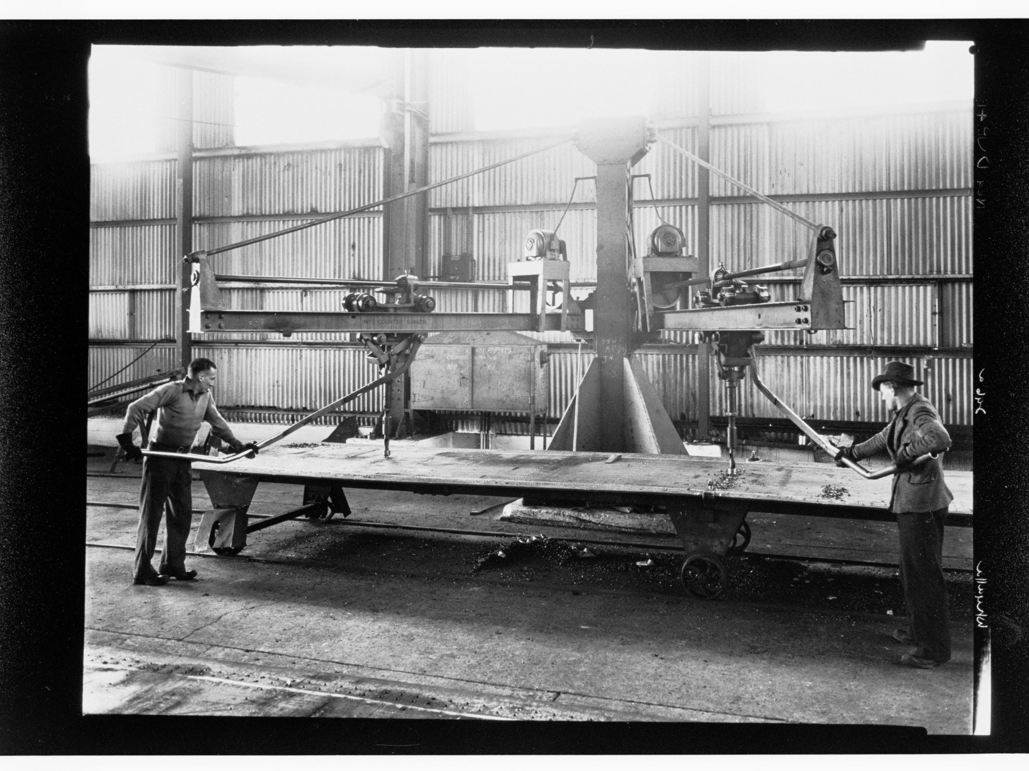 Whyalla - two men using equipment (No. 3 counter sinker)