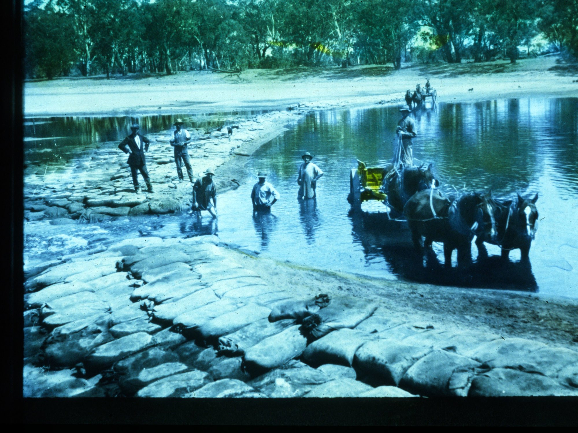Men Putting Sandbags Across River Murray