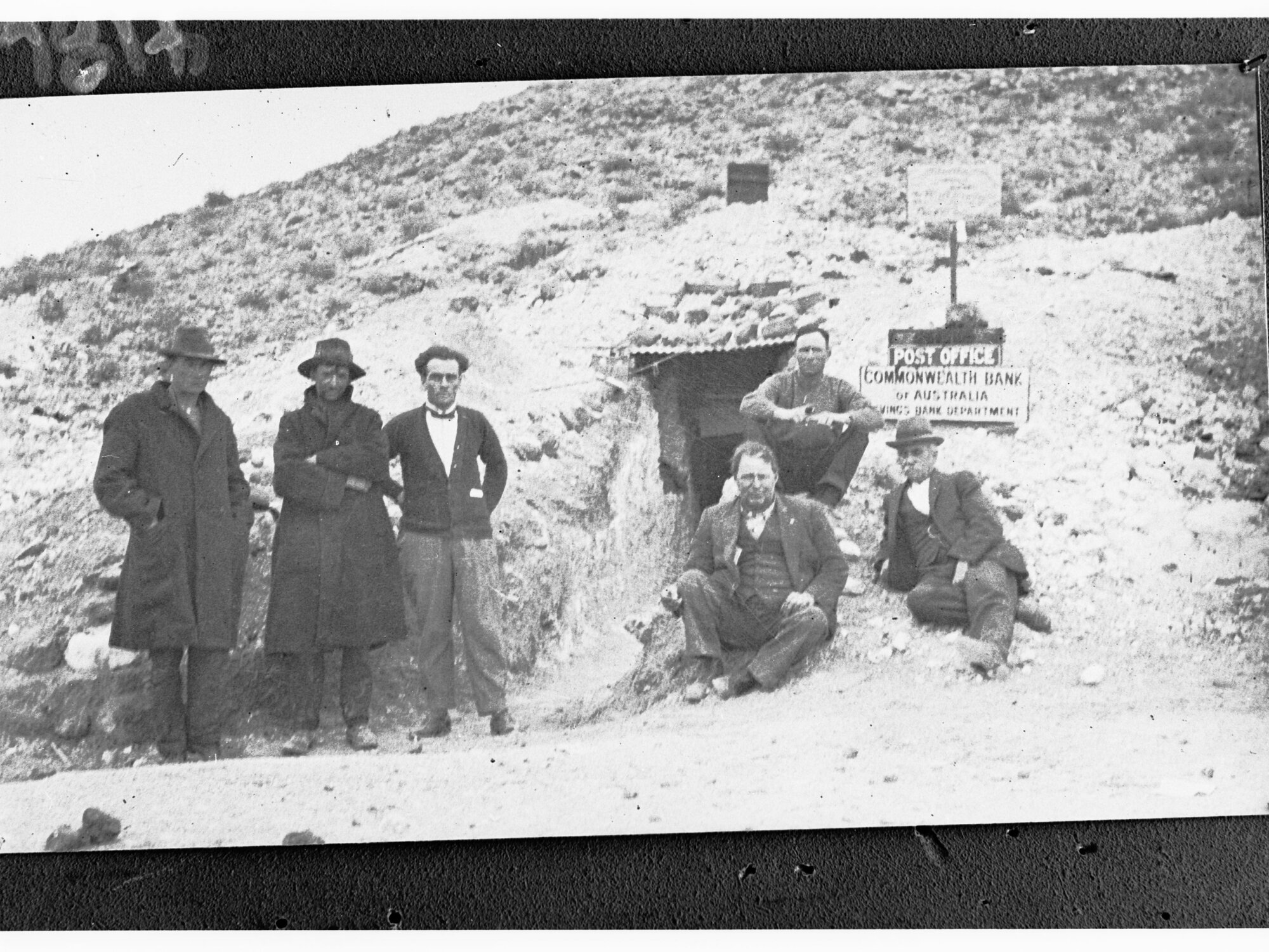 Men standing outside an underground post office - branch of Commonwealth Bank of Australia (Coober Pedy)