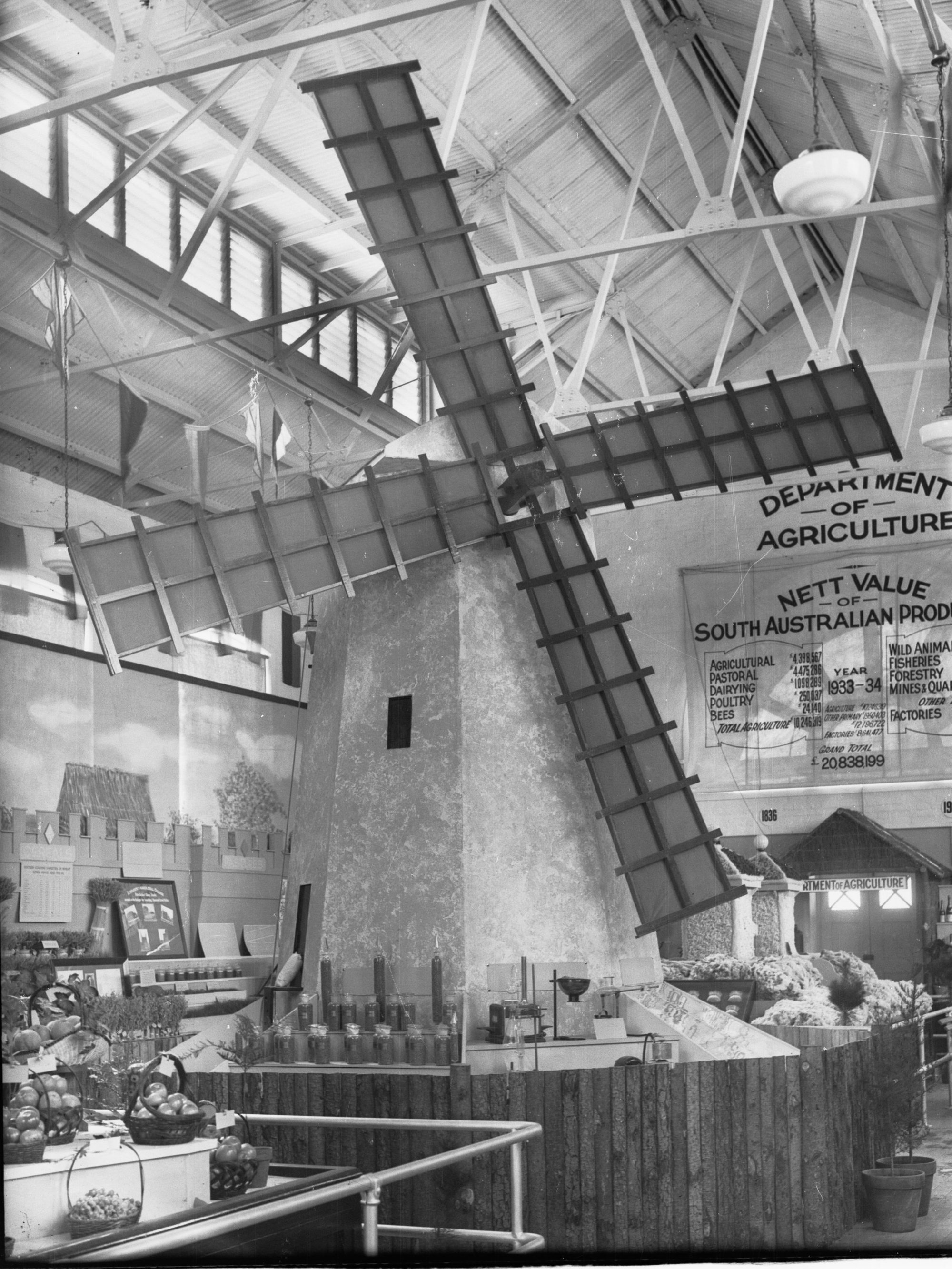 Exhibition for the Department of Agriculture showing windmill, grains surrounding windmill
