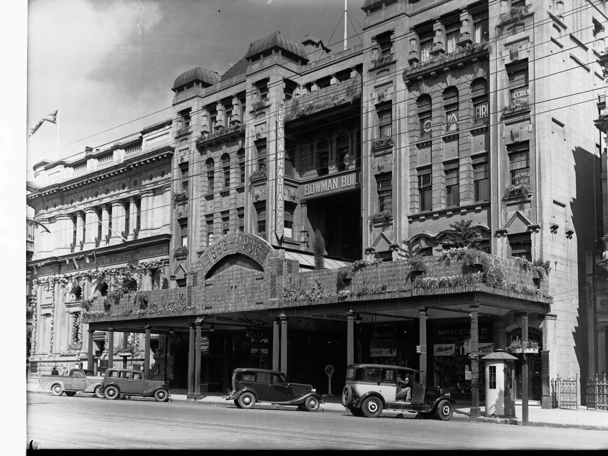 Bowman building King William Street decorated for State centenary, automobiles parked outside building