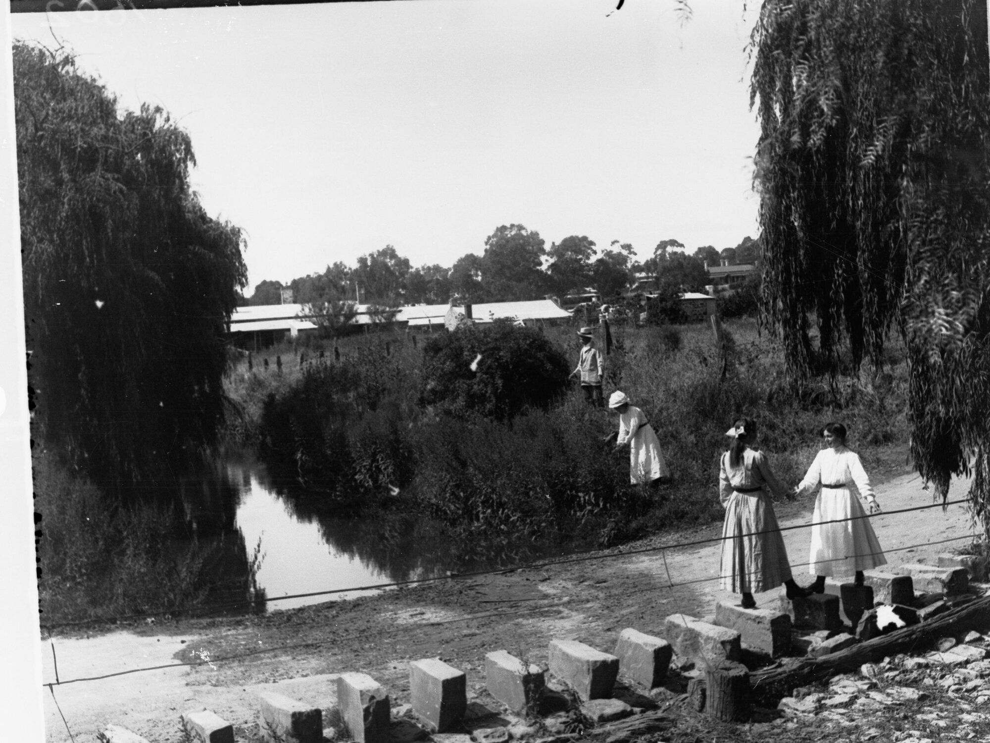 Young girls walking on stepping stones, Burton Street, Clare