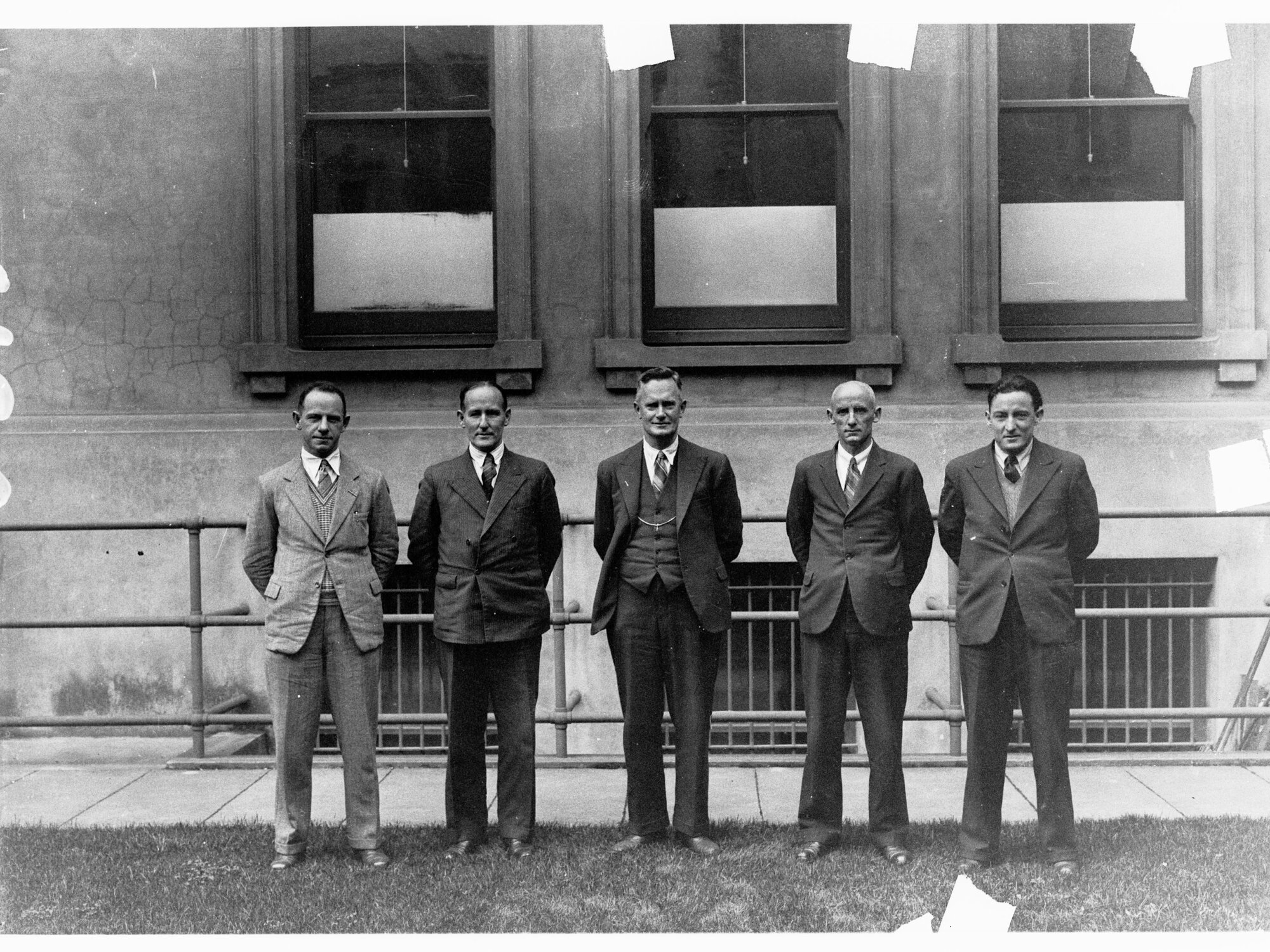 Five men standing in a row - unidentified