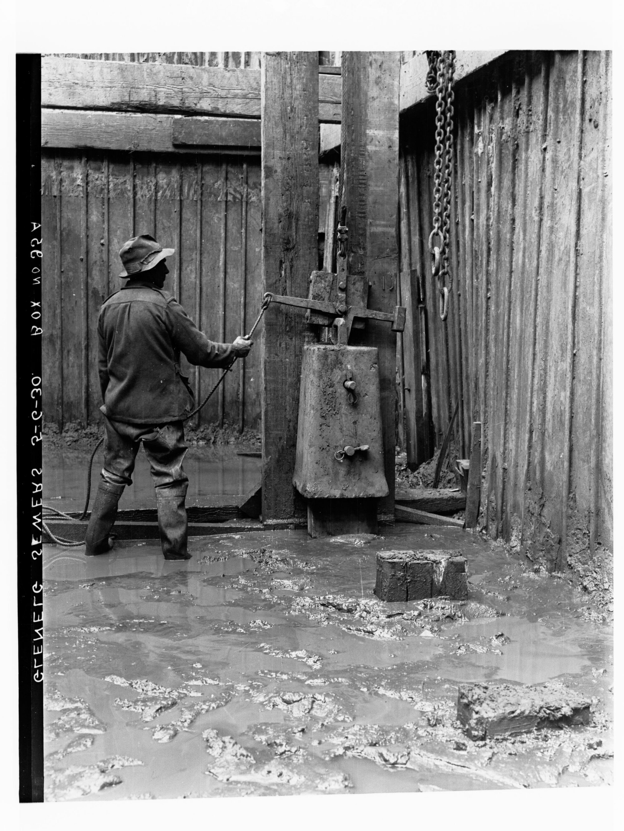 Glenelg Sewerage showing man in a trench operating a pile driver