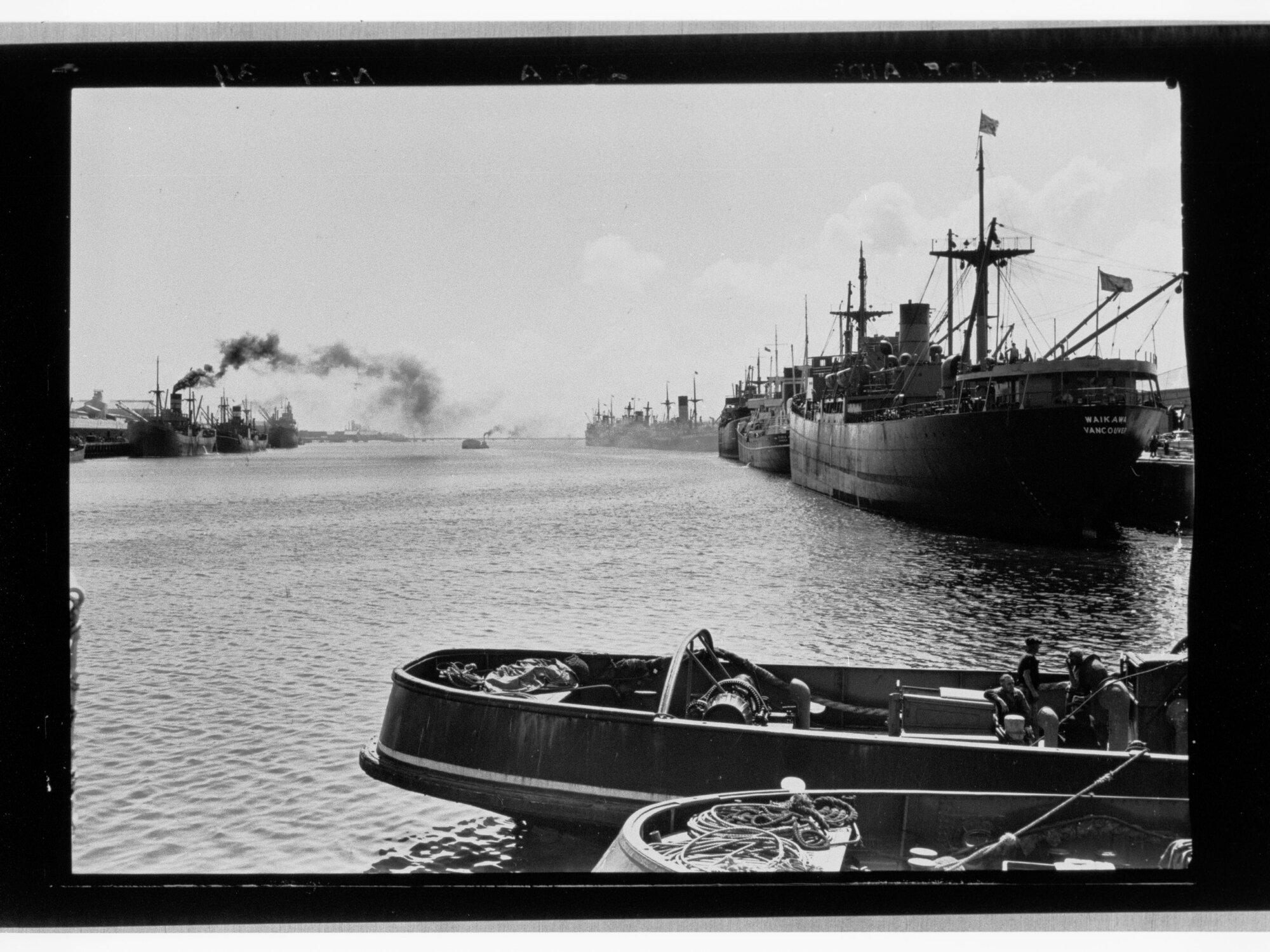 Ships and tugs lined up alongside dock
