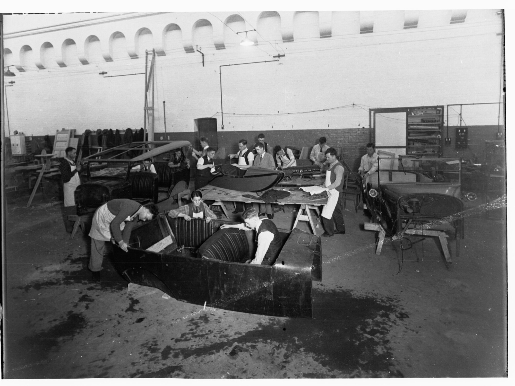 Students working on automobiles at trades school