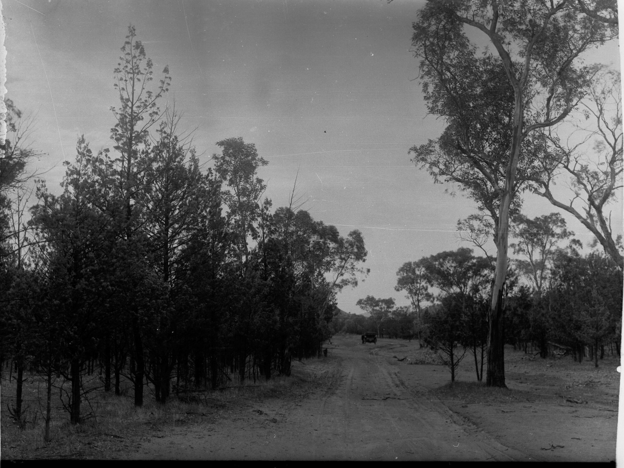 Rural view showing dirt road and automobile