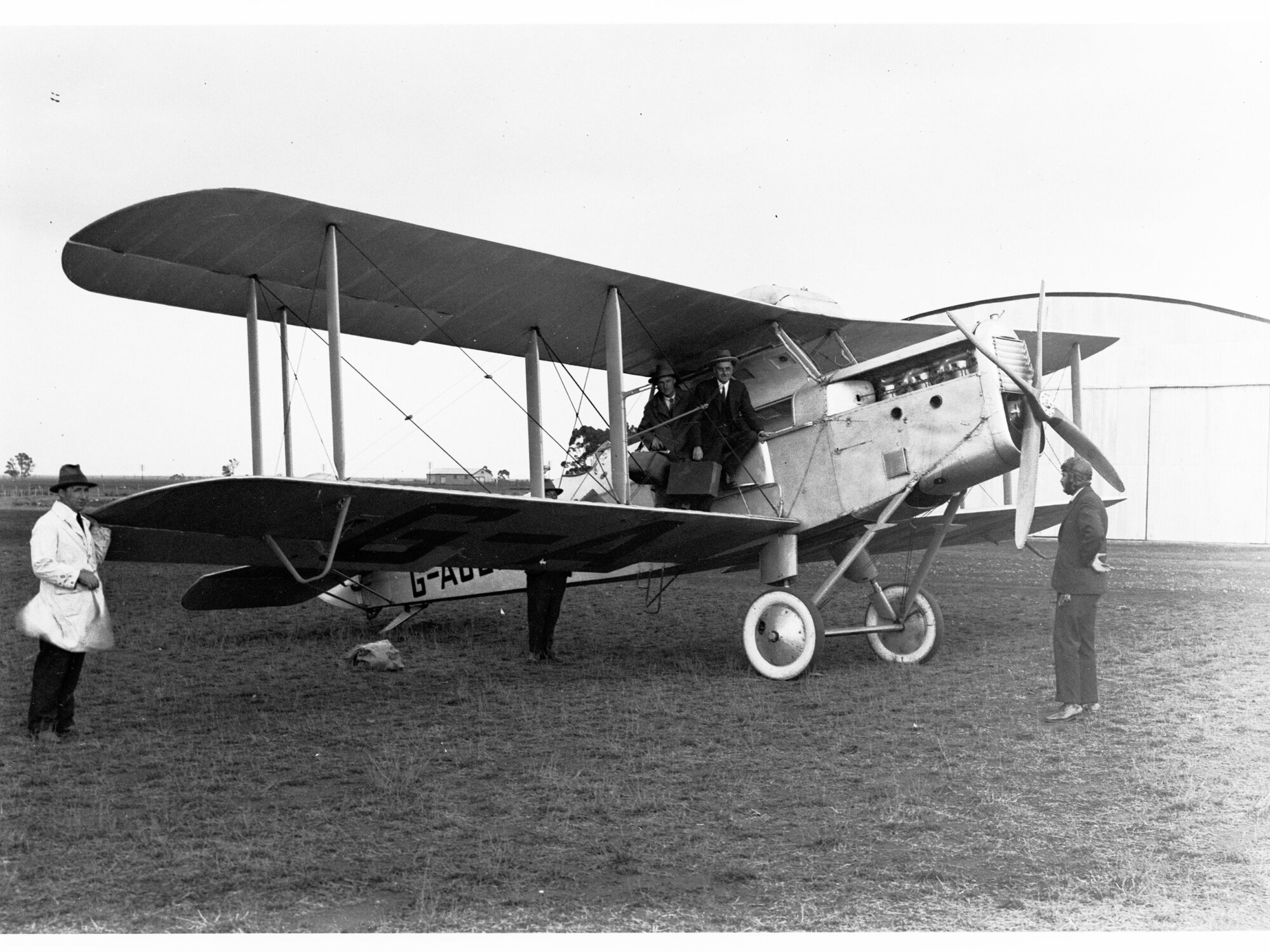 A de Havilland aeroplane, a DH50A, named Bellbird (probably located at an aerodrome in Parafield) - two men getting into plane