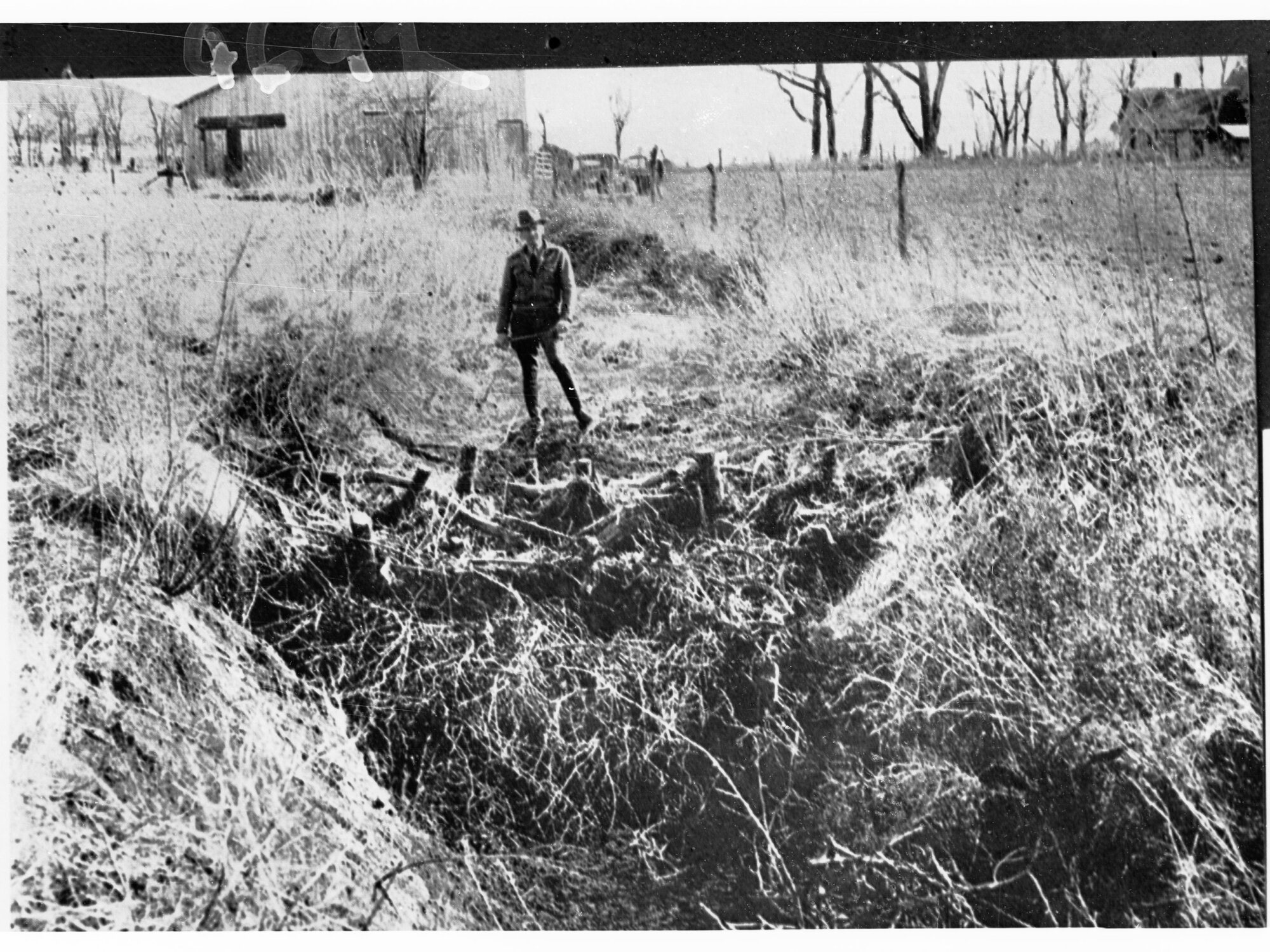 Man Standing by a Small Home-Made Dam