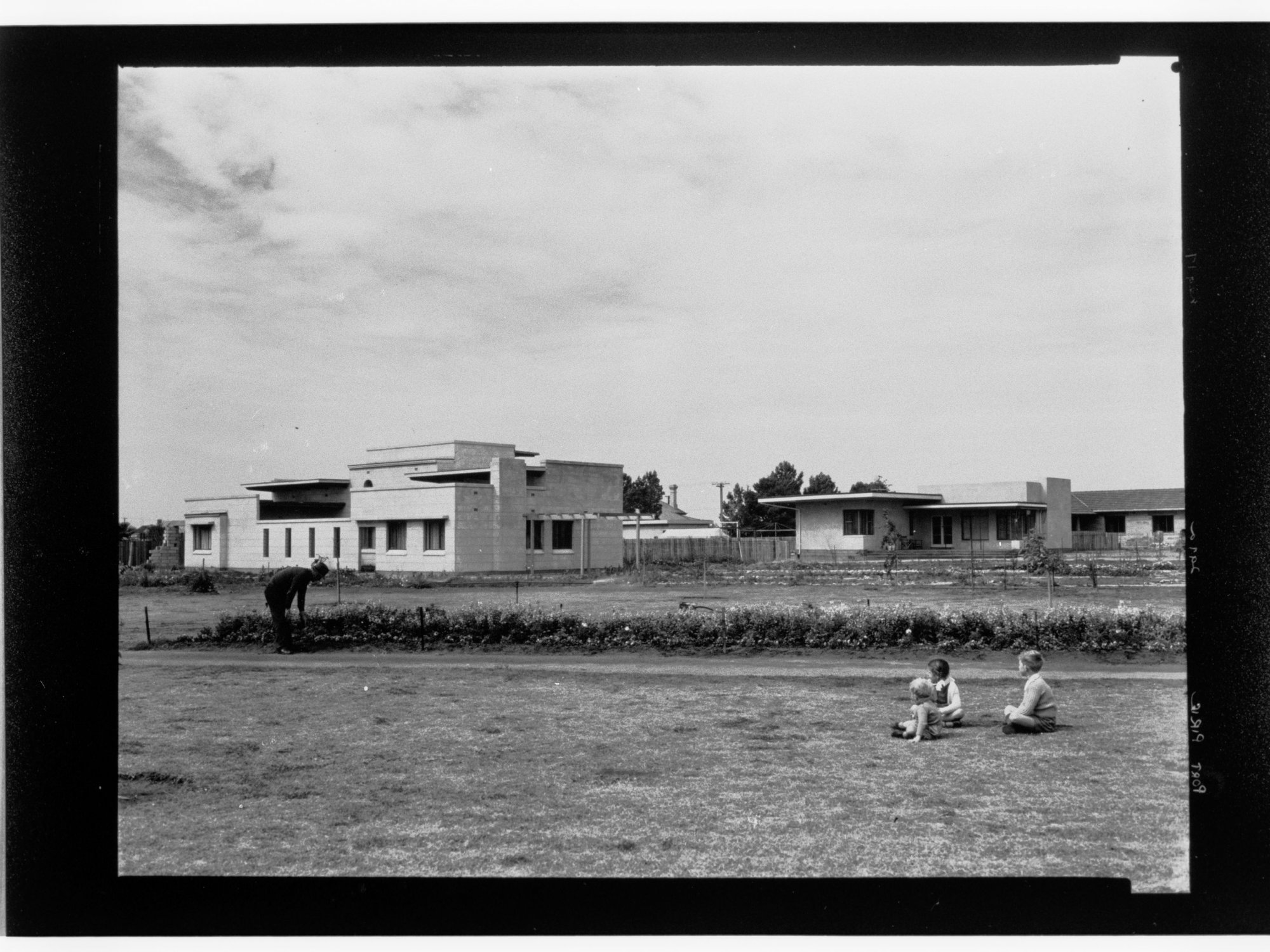 Port Pirie - three children sitting on grass looking over at some buildings
