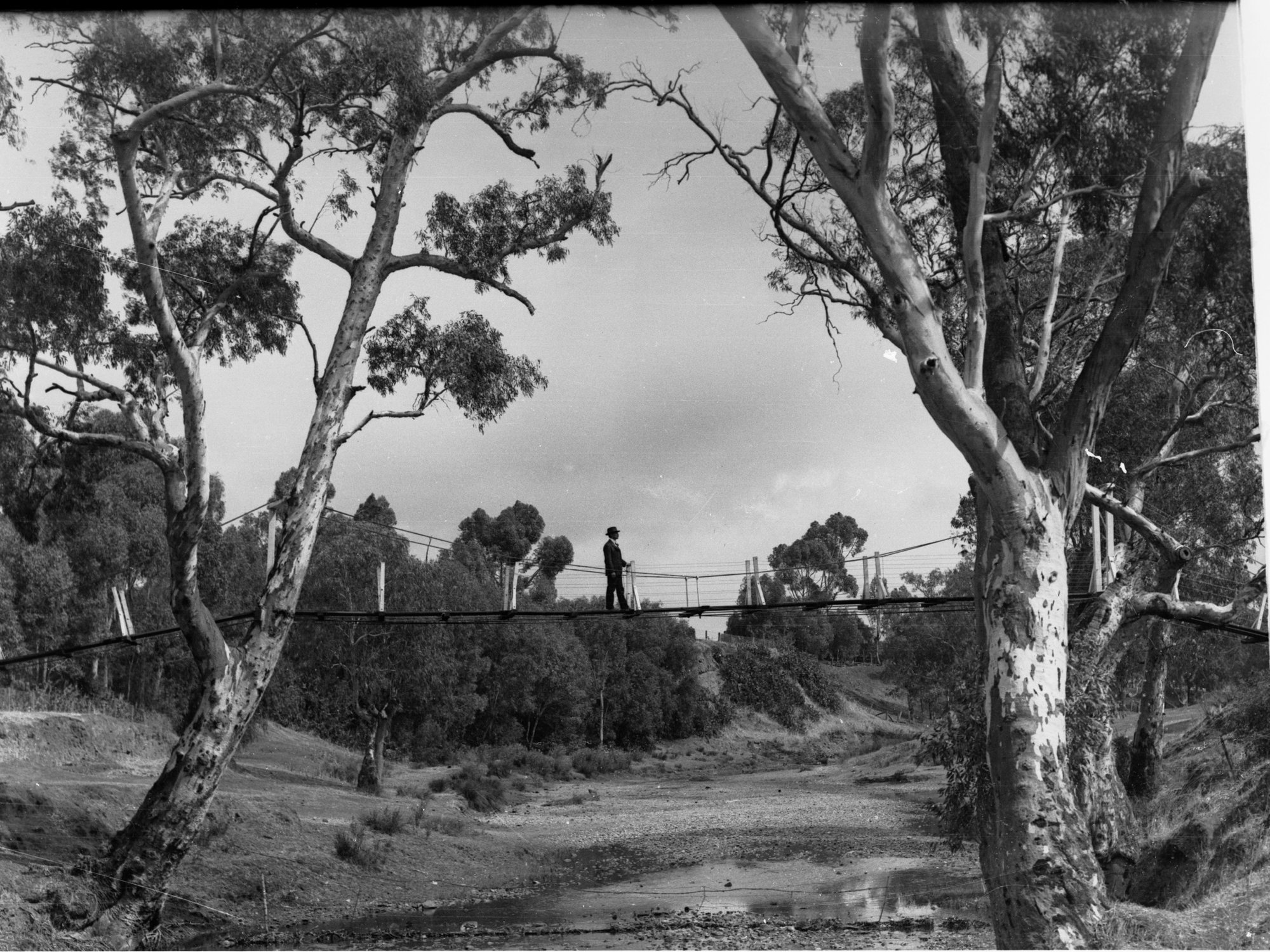 Man crossing footbridge over creek