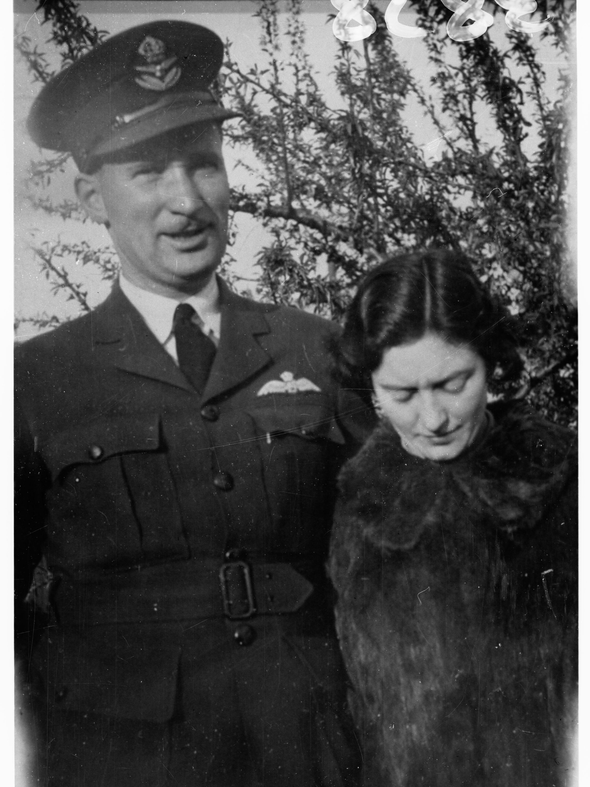 Portrait of an officer in Royal Australian Air Force - photo copied for Roll of Honour (lady is also in photograph))