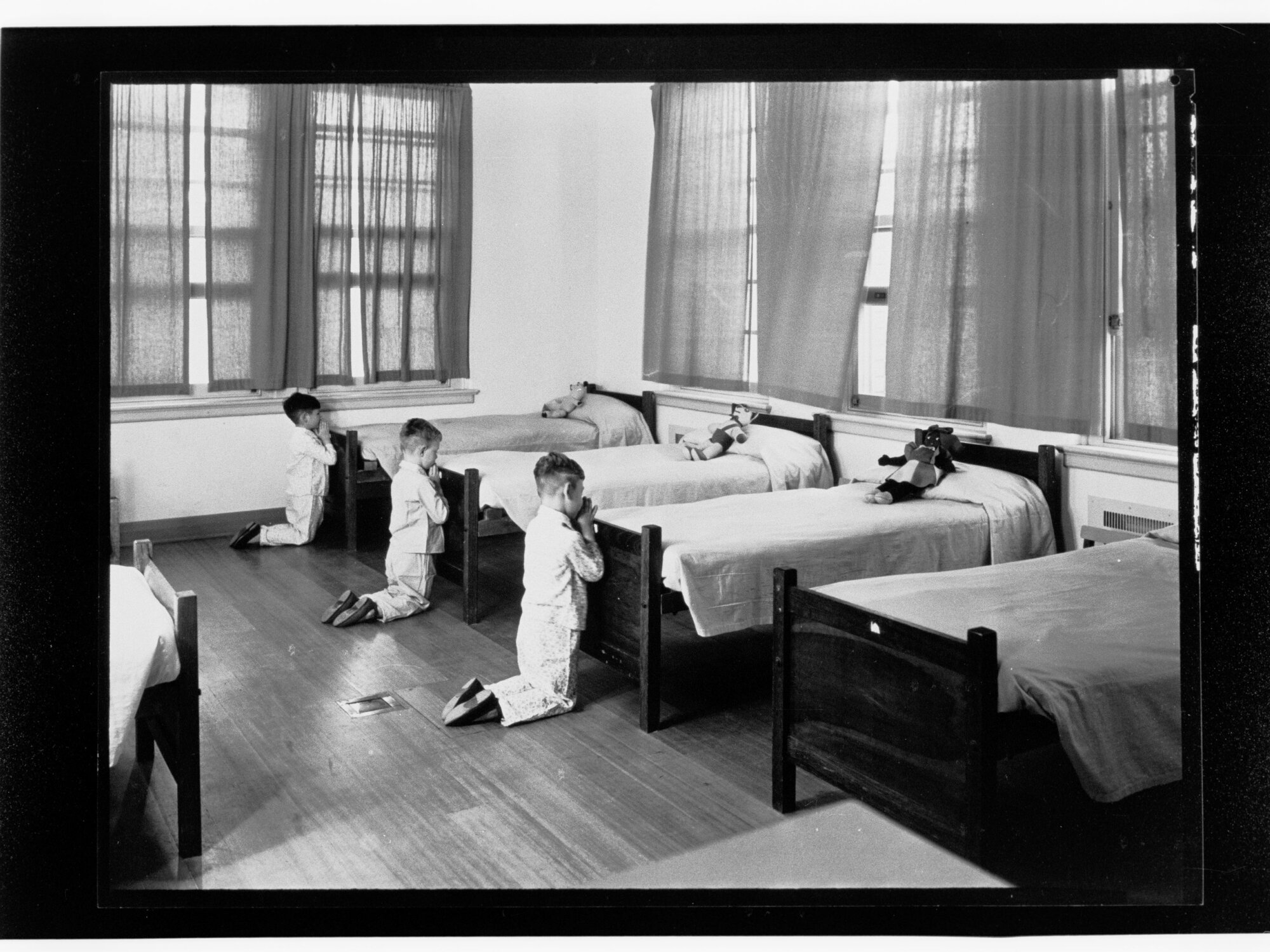 Children's Welfare Department - boys kneeling praying at foot of beds