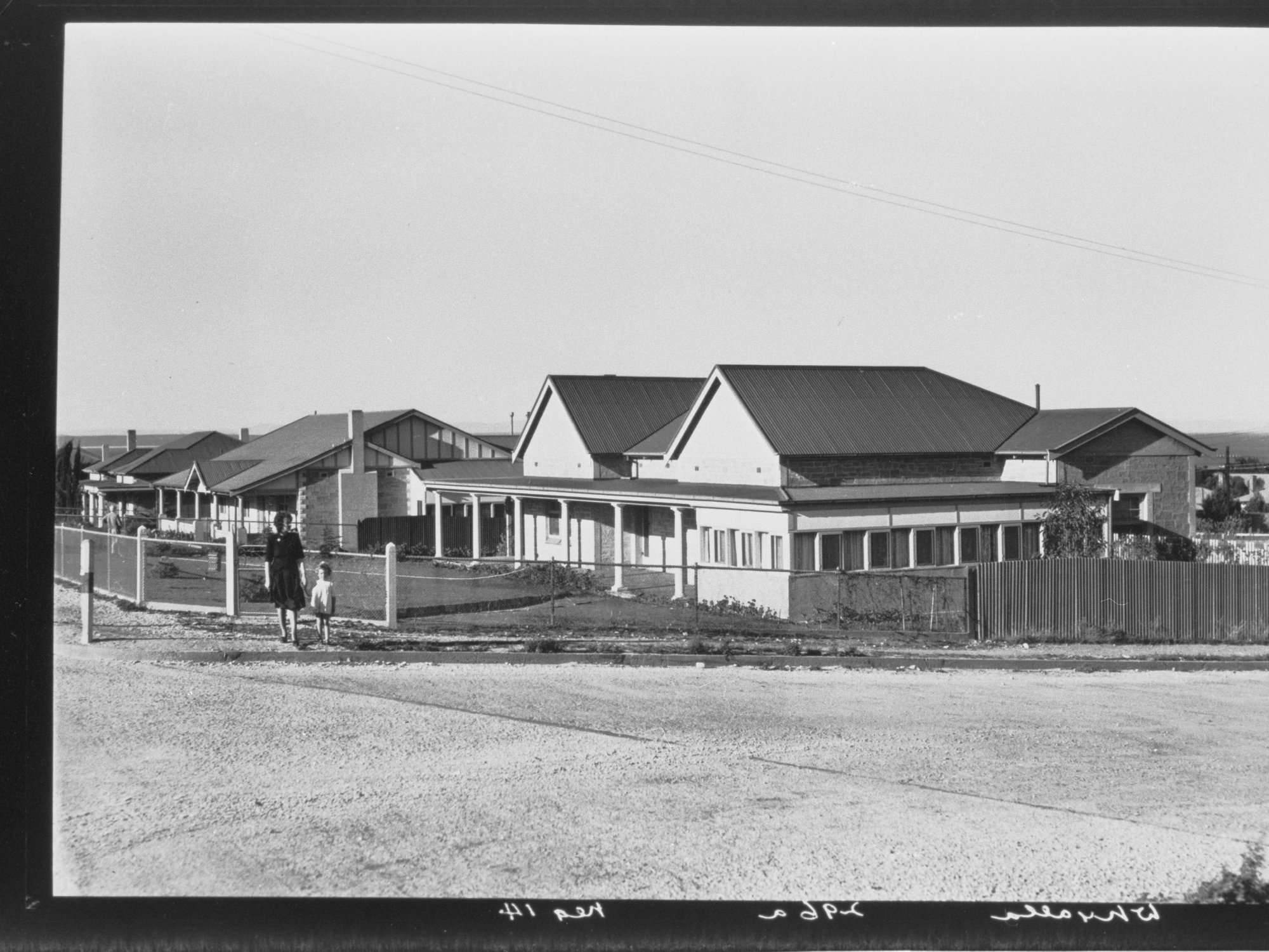 Whyalla - woman and child standing at the corner near some houses