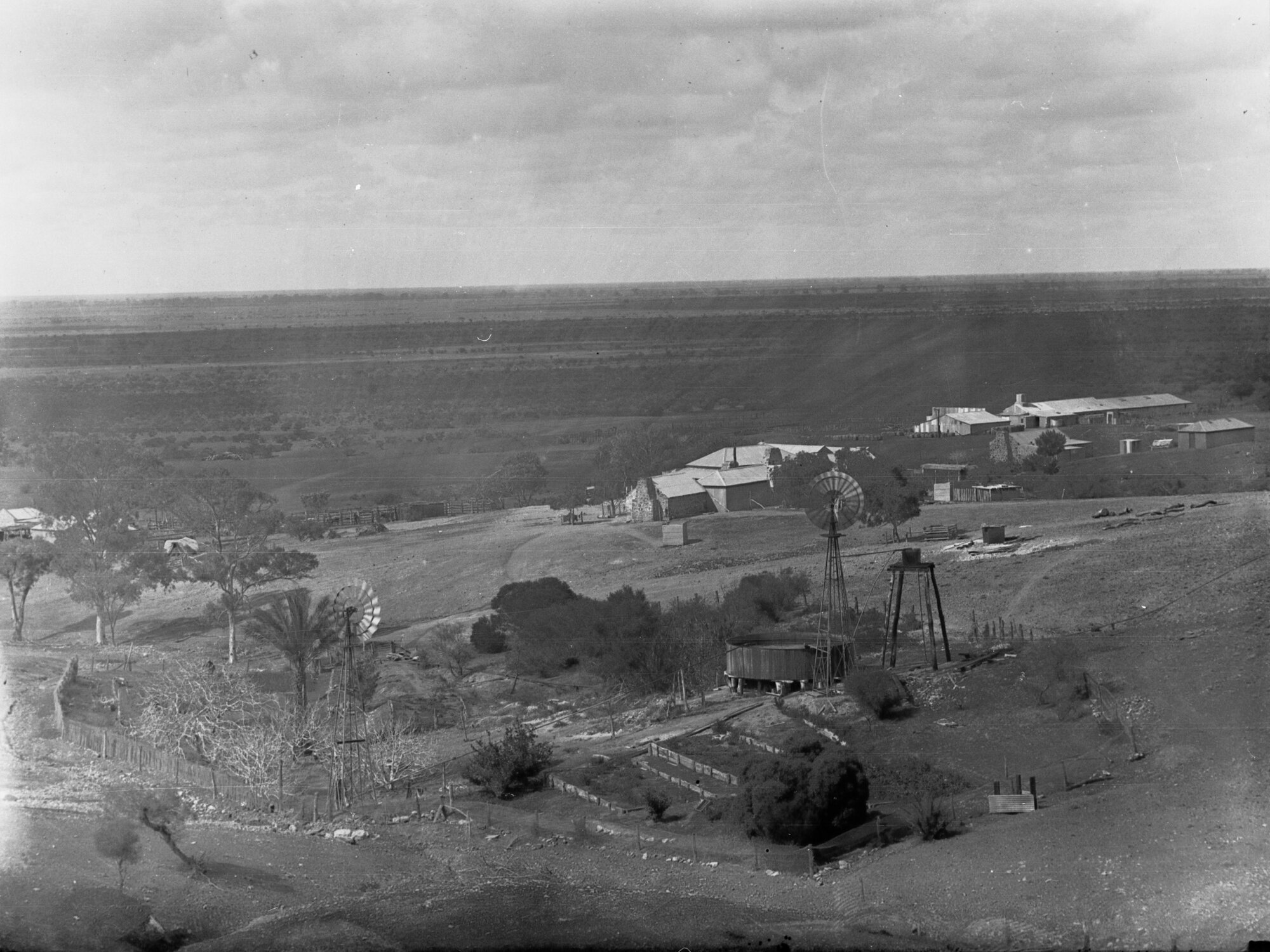 Farming land showing farm buildings, rain water tank and wind mill