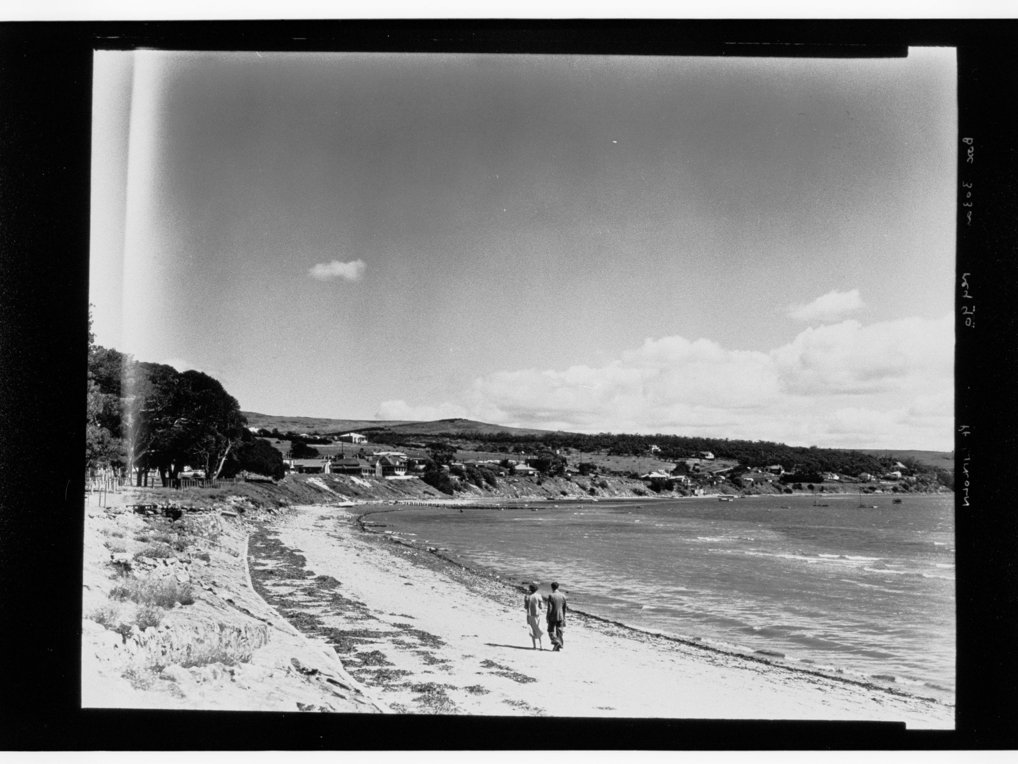 Two people walking on beach