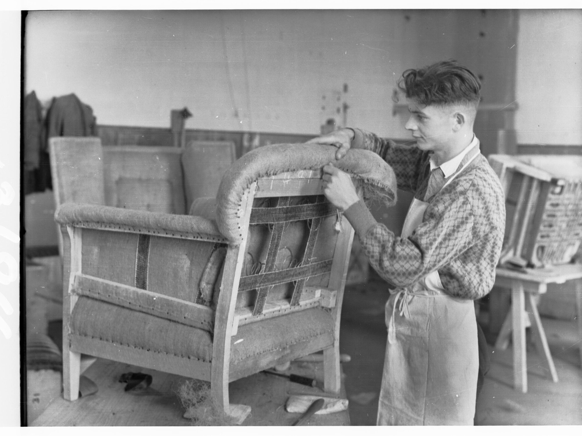 Students upholstering chair at trade school