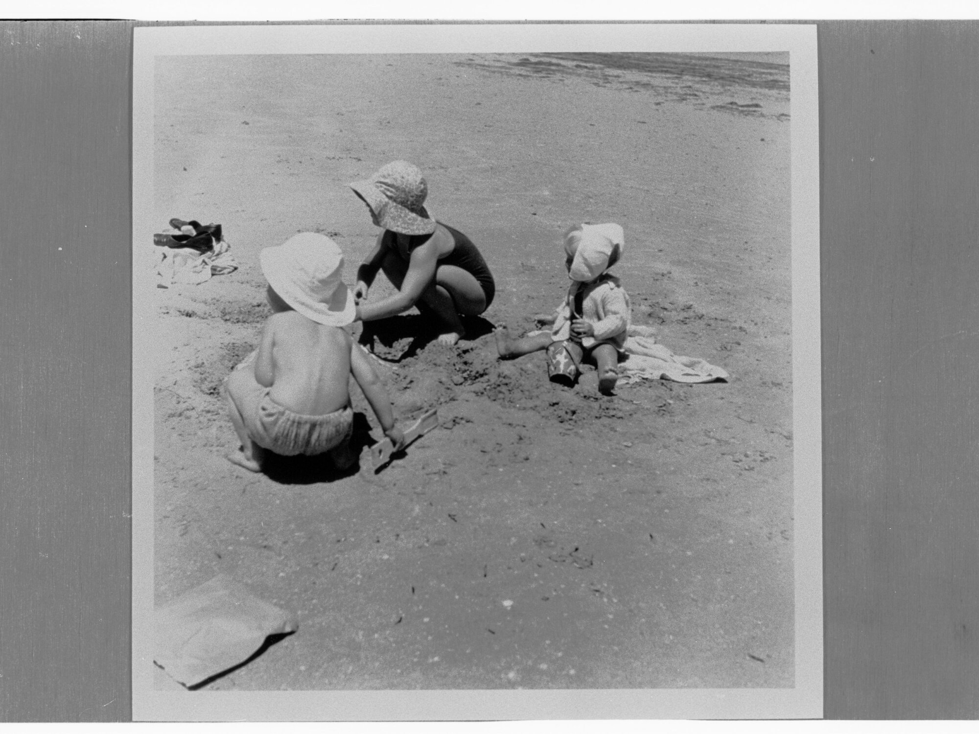 Three children playing in the sand