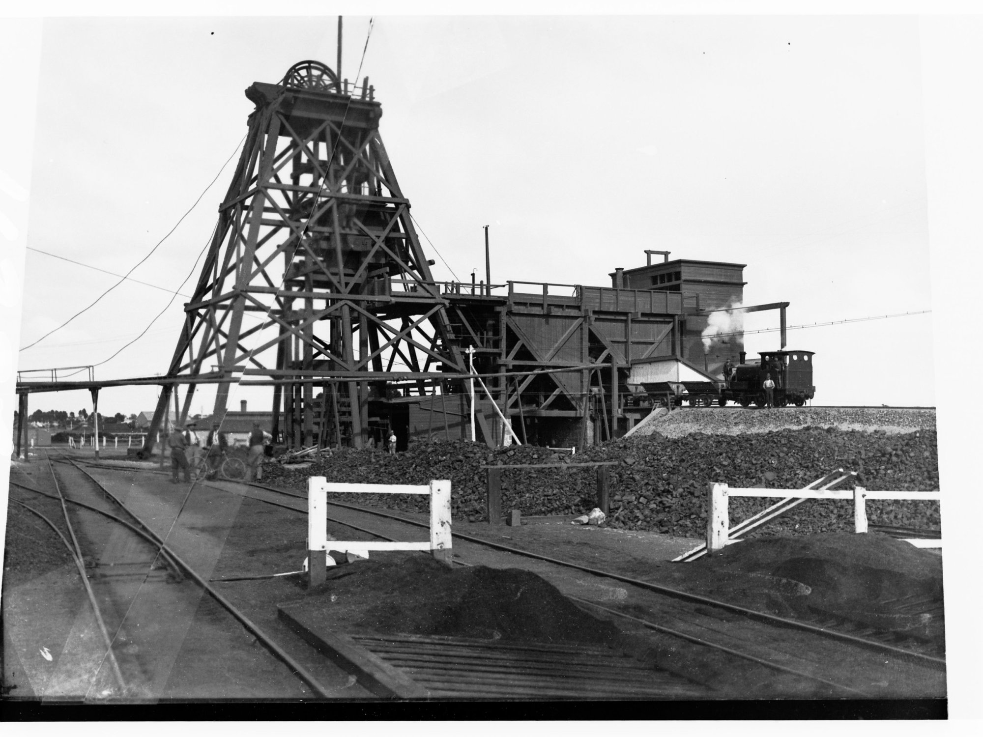 Moonta Mines view of Taylor Head Gear and Ore Sorting Plant - Men standing in front of plant with a bicycle