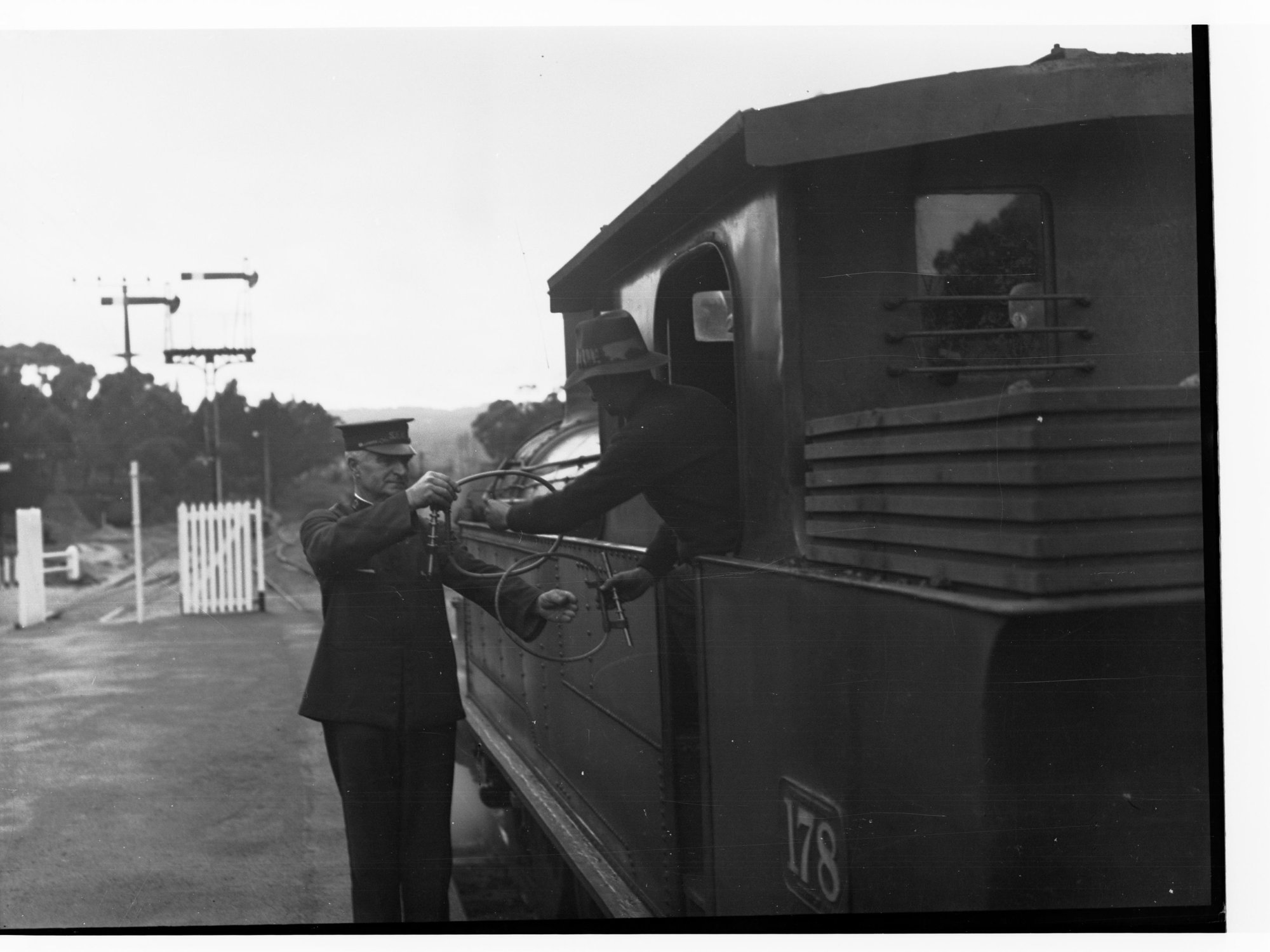 Railway conductor near locomotive, Belair