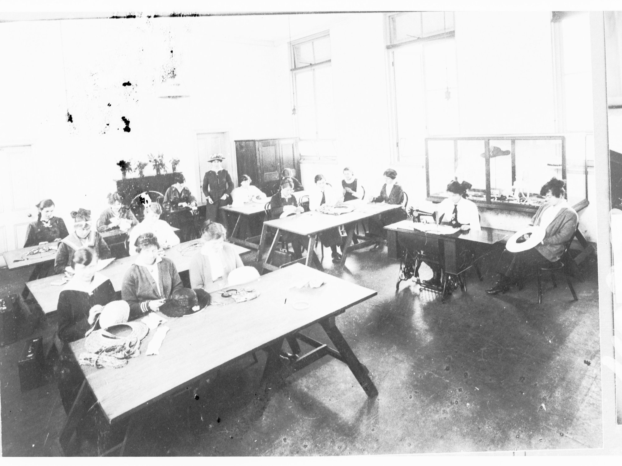Girls in a class learning millinery skills