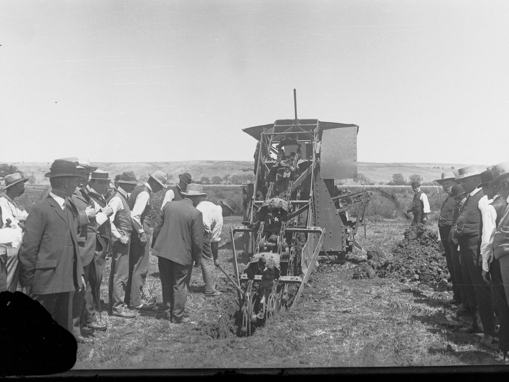 Men Observing a Mechanical Ditch Digger at Work