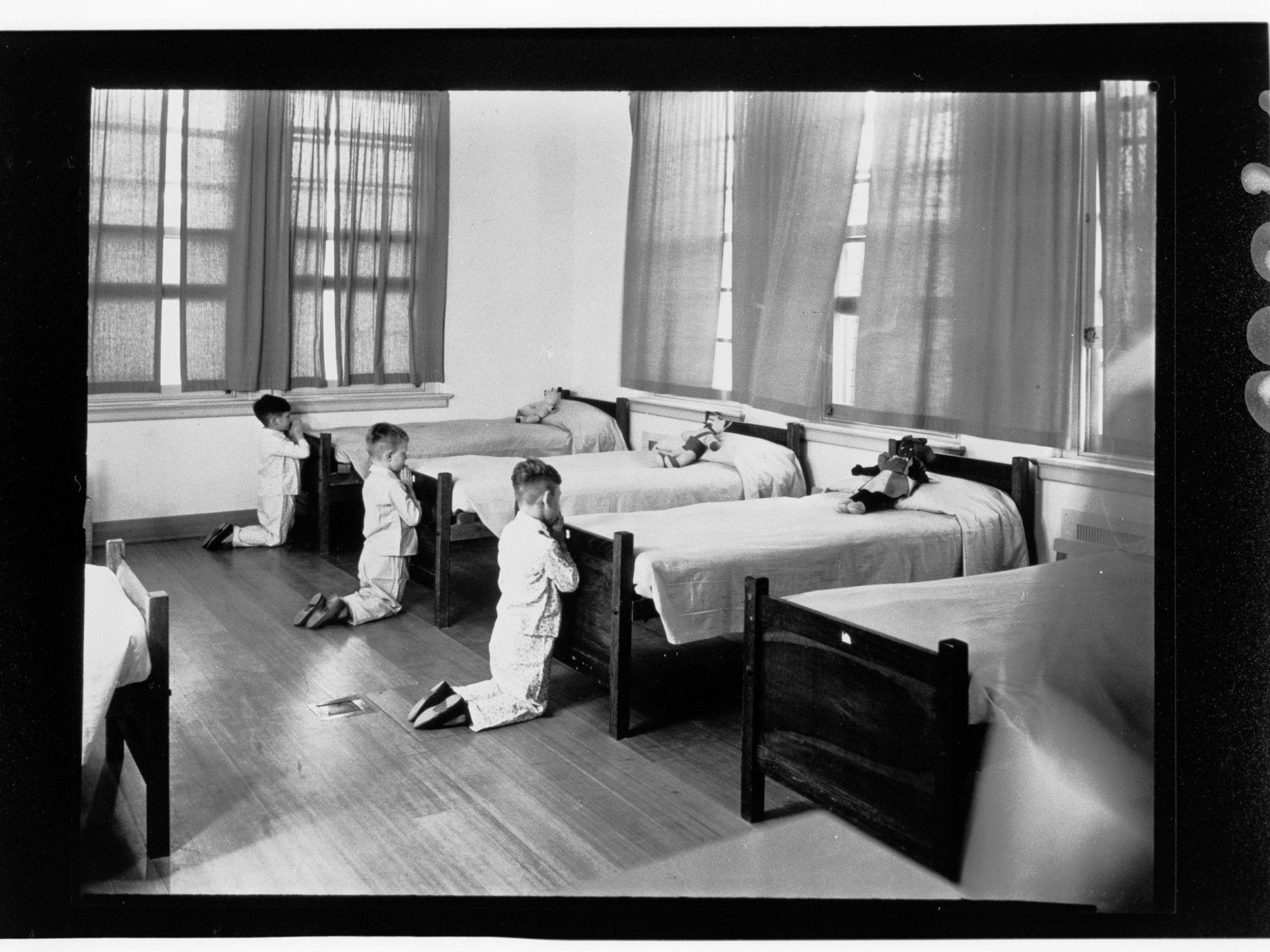Children's Welfare Department - boys kneeling praying at foot of beds