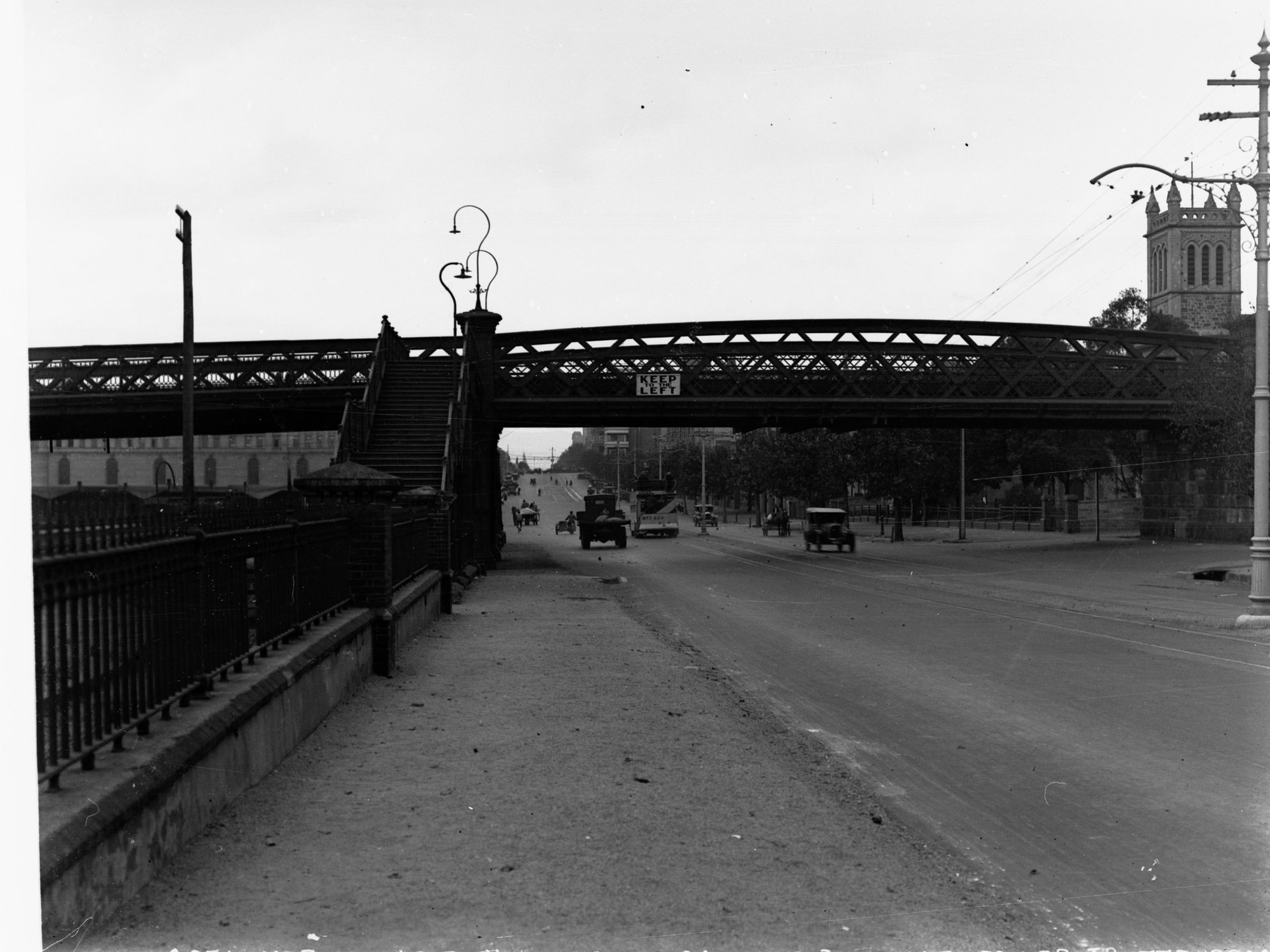 Morphett Street bridge overway looking east showing automobiles on North Terrace, Holy Trinity Church of England in the background.