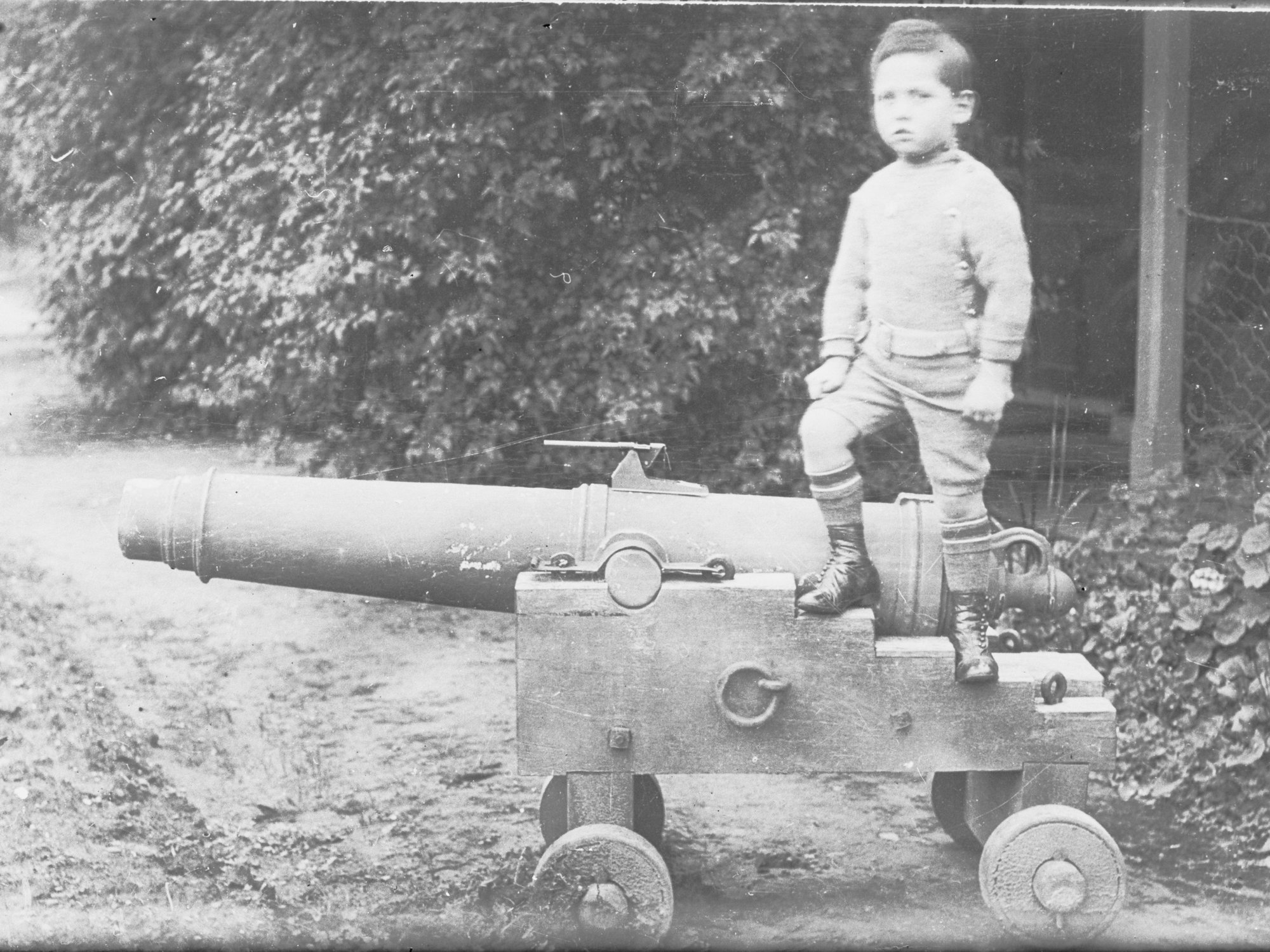 View of a little boy standing on a canon 