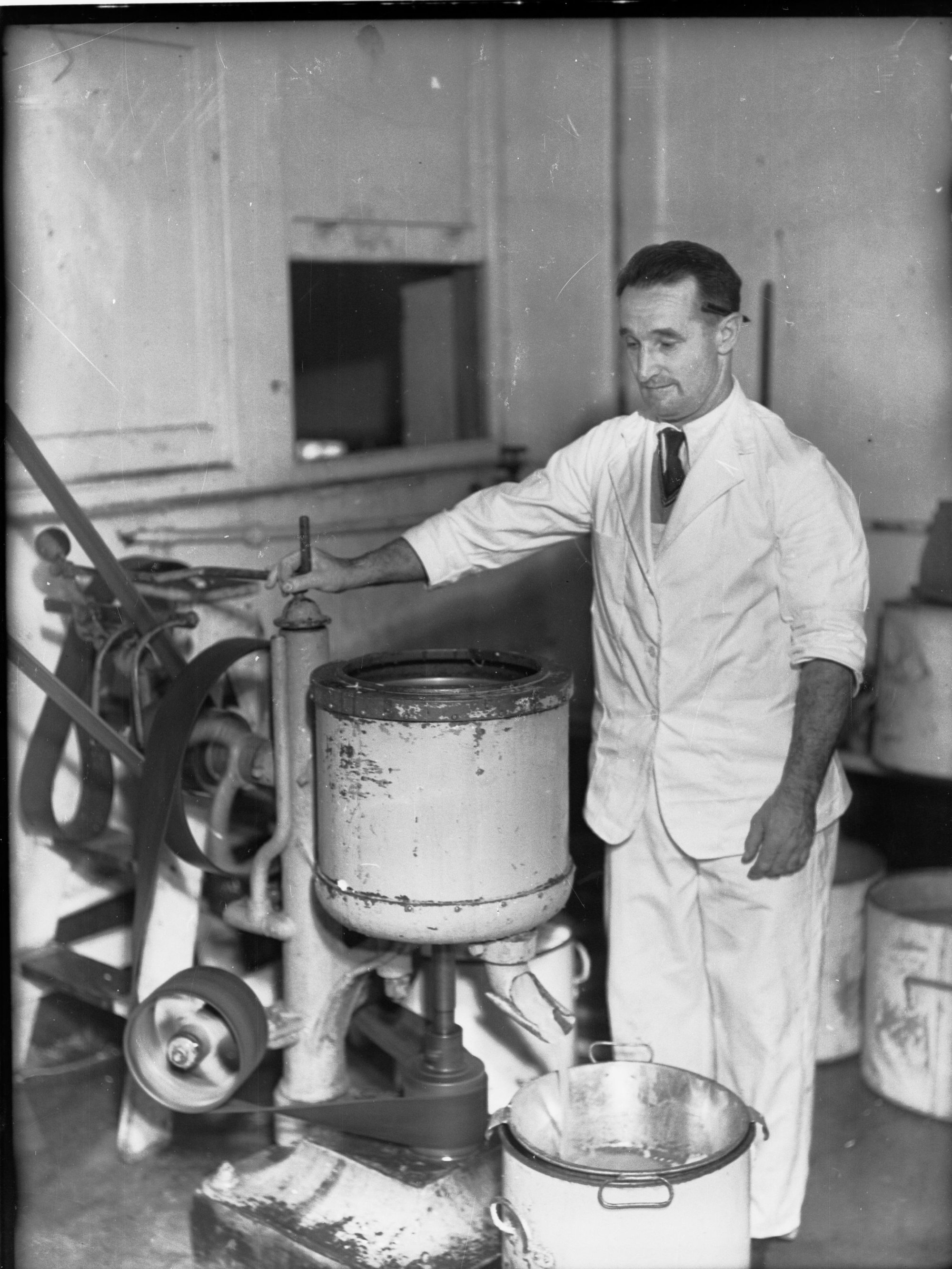 Egg pulping at Farmer's Union, man standing by a machine