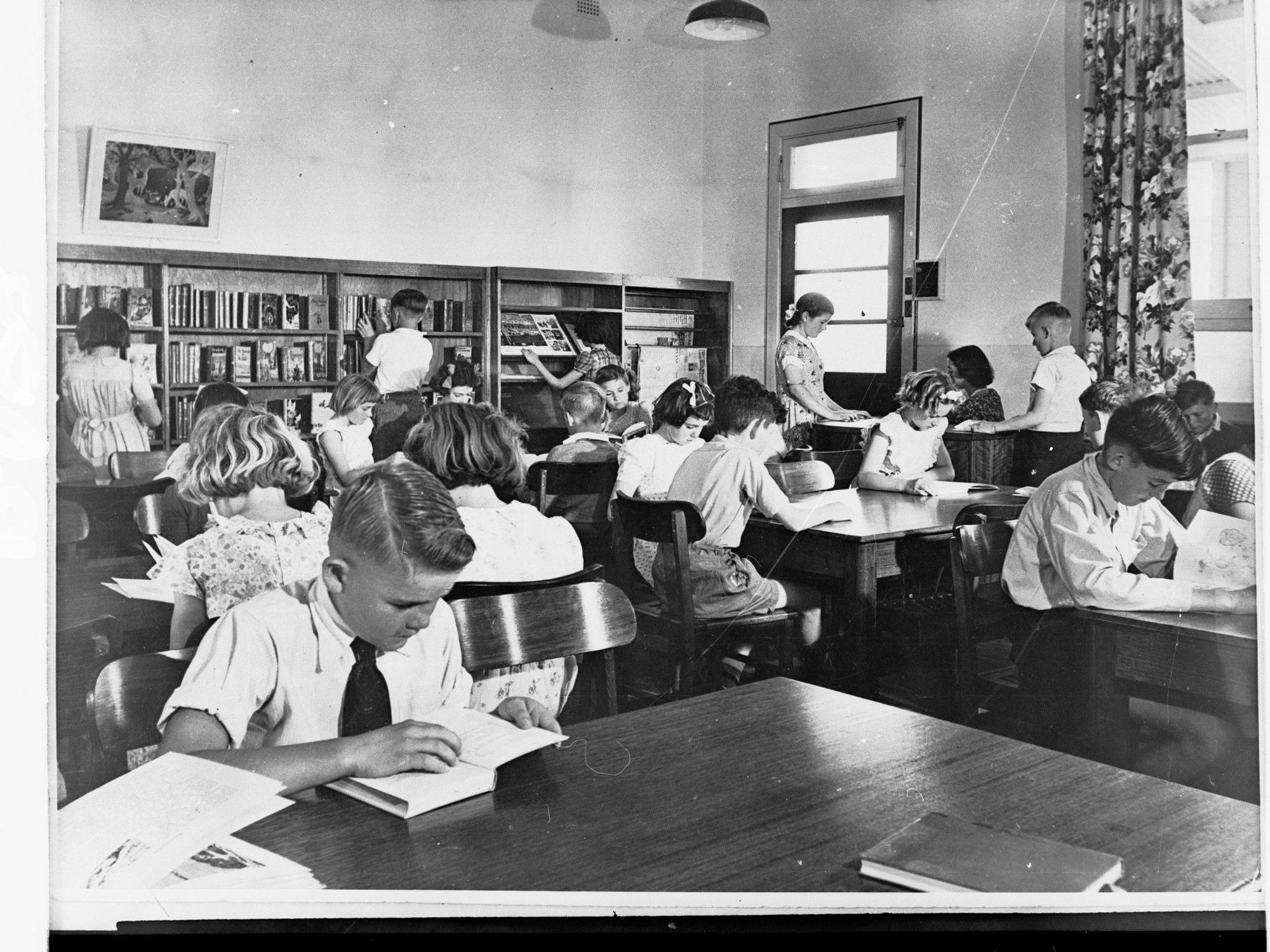 Children Reading at Tables in a School Library