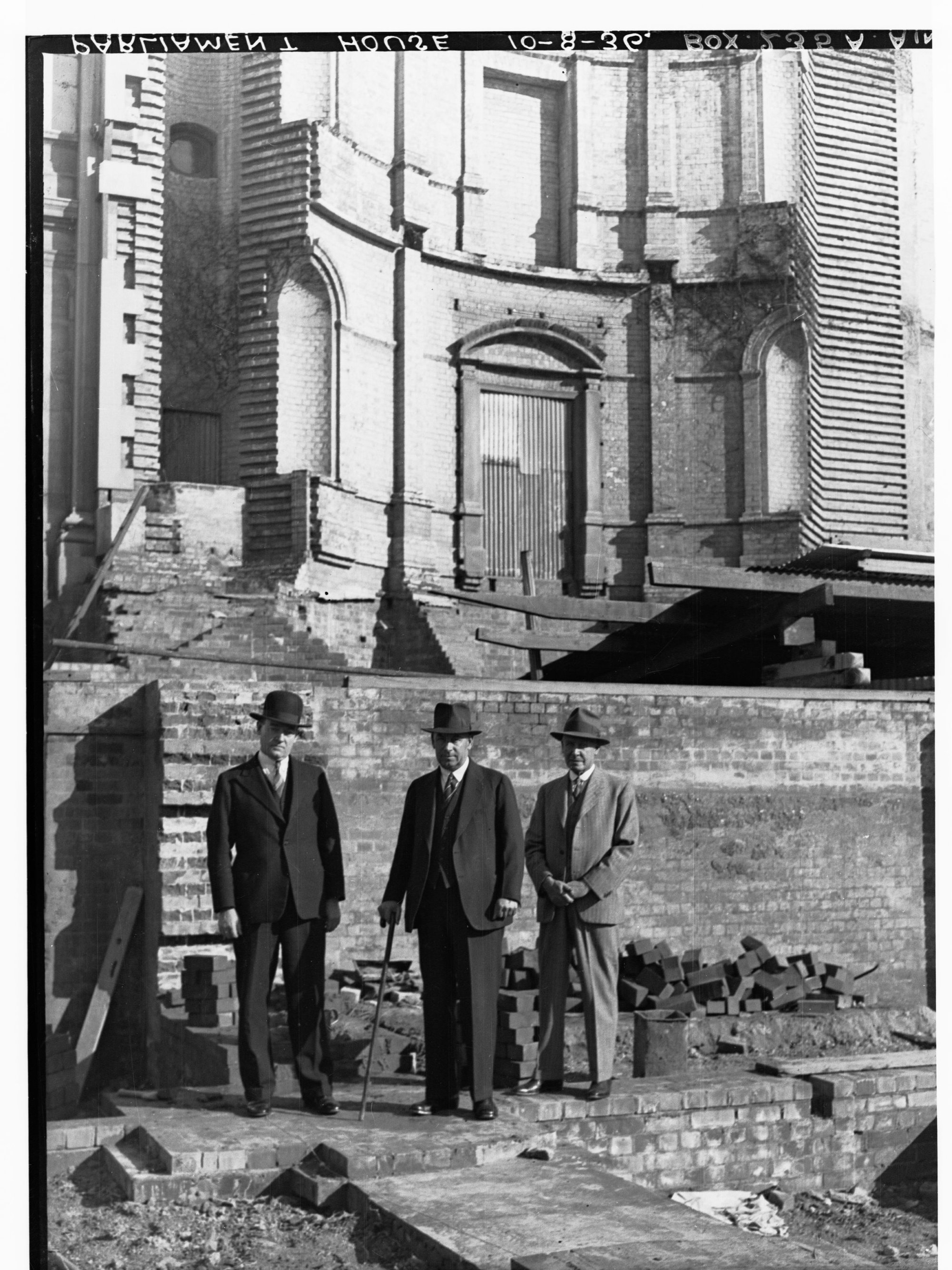 Three men outside Parliament House during construction of extension
