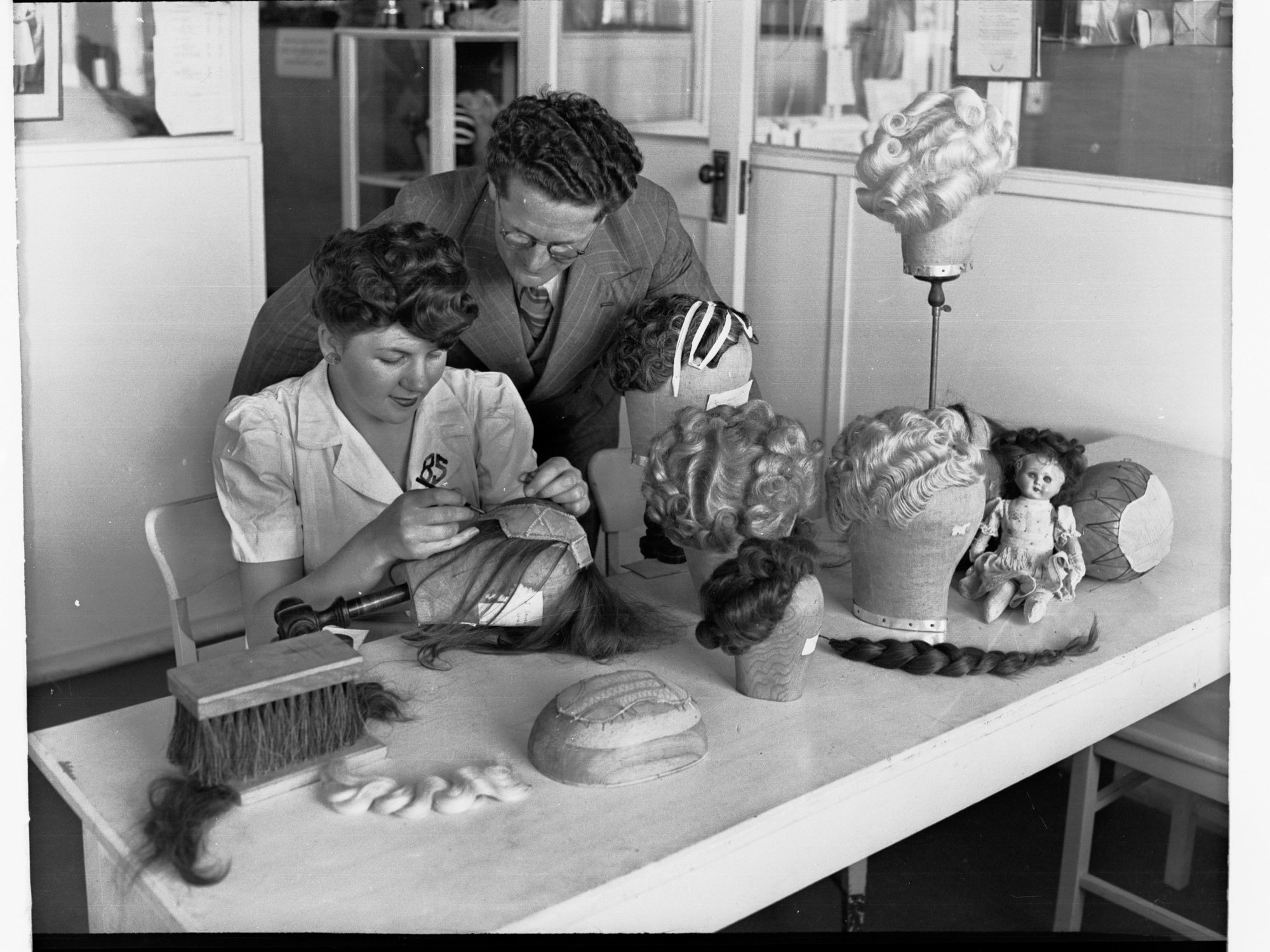 Women Making a Wig Being Supervised by a Man